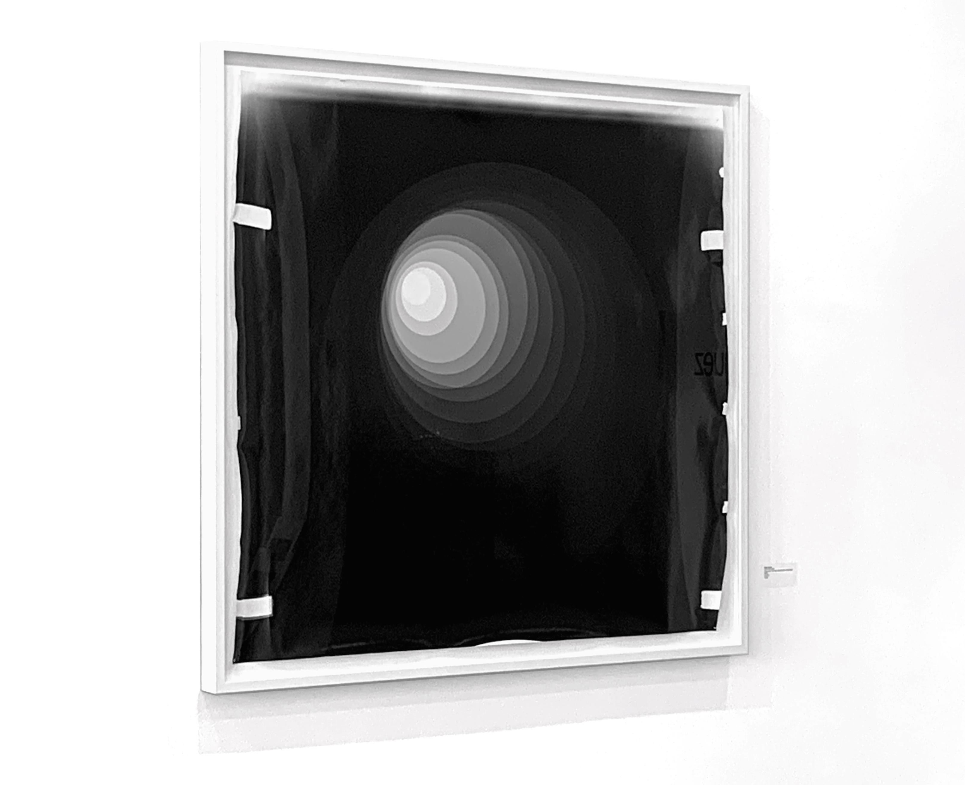 Black and white unique silver gelatin print, (chemical print on fiber-based paper), in white frame.

Betsy Kenyon’s work is a merging of different processes; using darkroom techniques as her medium, Kenyon blurs established lines between drawing,