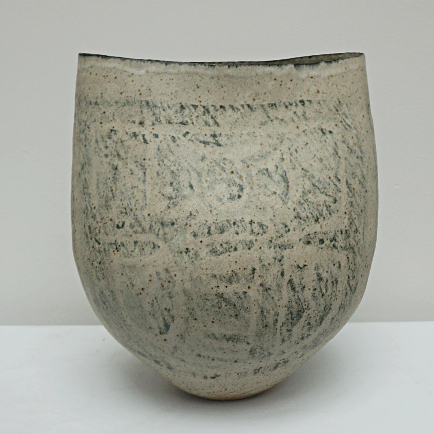 A large coiled stoneware pot with a squeezed rim by Betty Blandino b. 1927. 

Origin: English

Date: Circa 1980

Betty Blandino was born in London. She studied painting and pottery at Goldsmiths College, London. She used the hand building