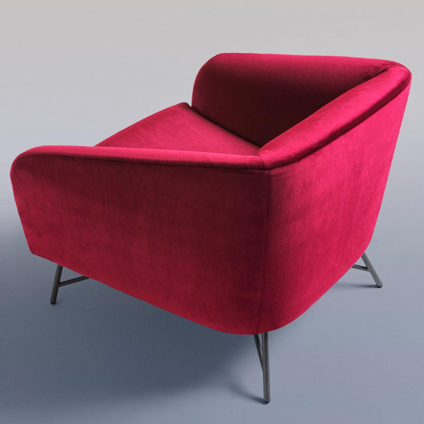 Gentle slopes and bold volumes define the enthralling look of this armchair with a wooden frame, ideal for enlivening modern settings with its vibrant burgundy velvet upholstery. Cylindrical elements dynamically arranged to comprise the