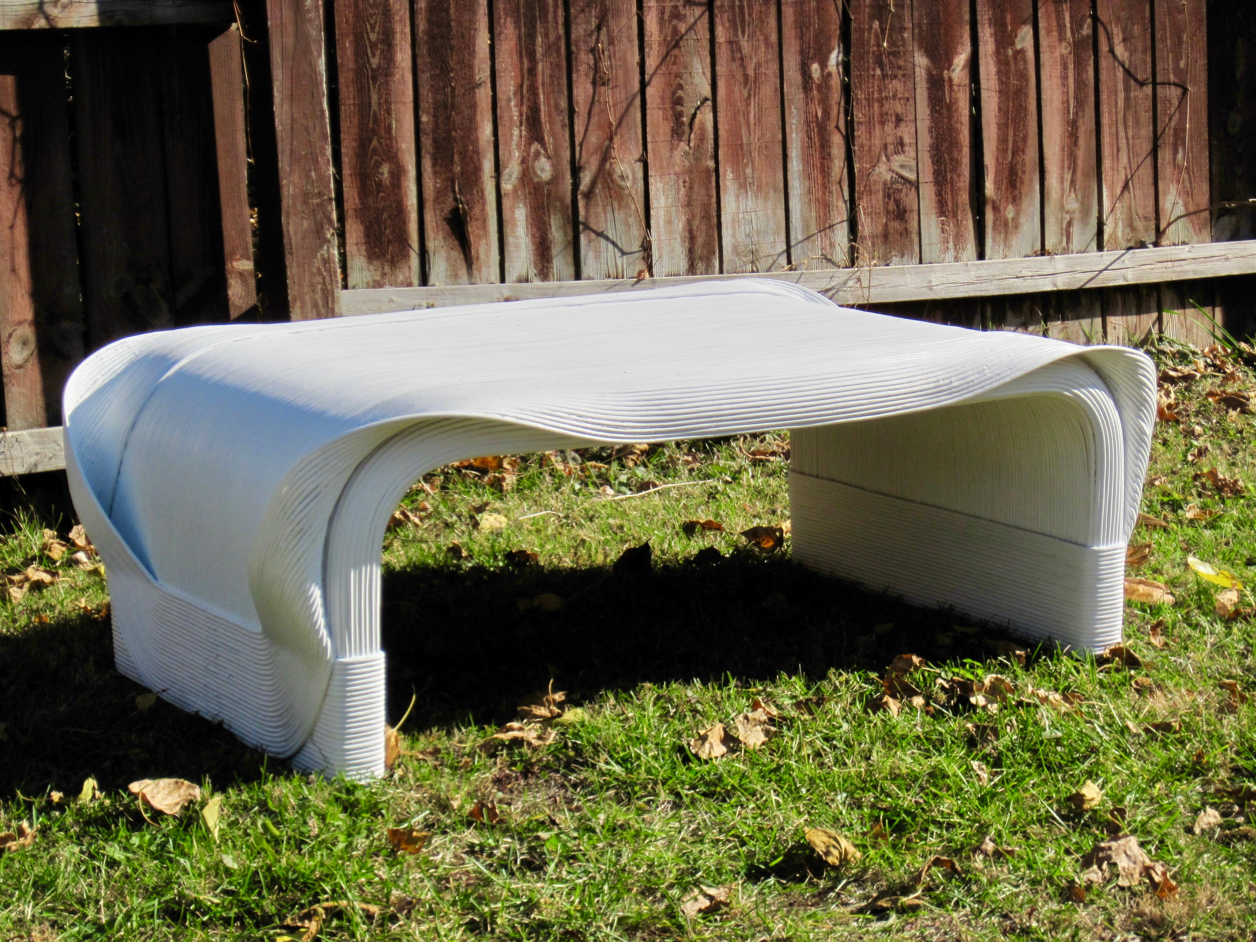 An organic modern bent reed coffee table in white by Betty Cobonpue part of her 