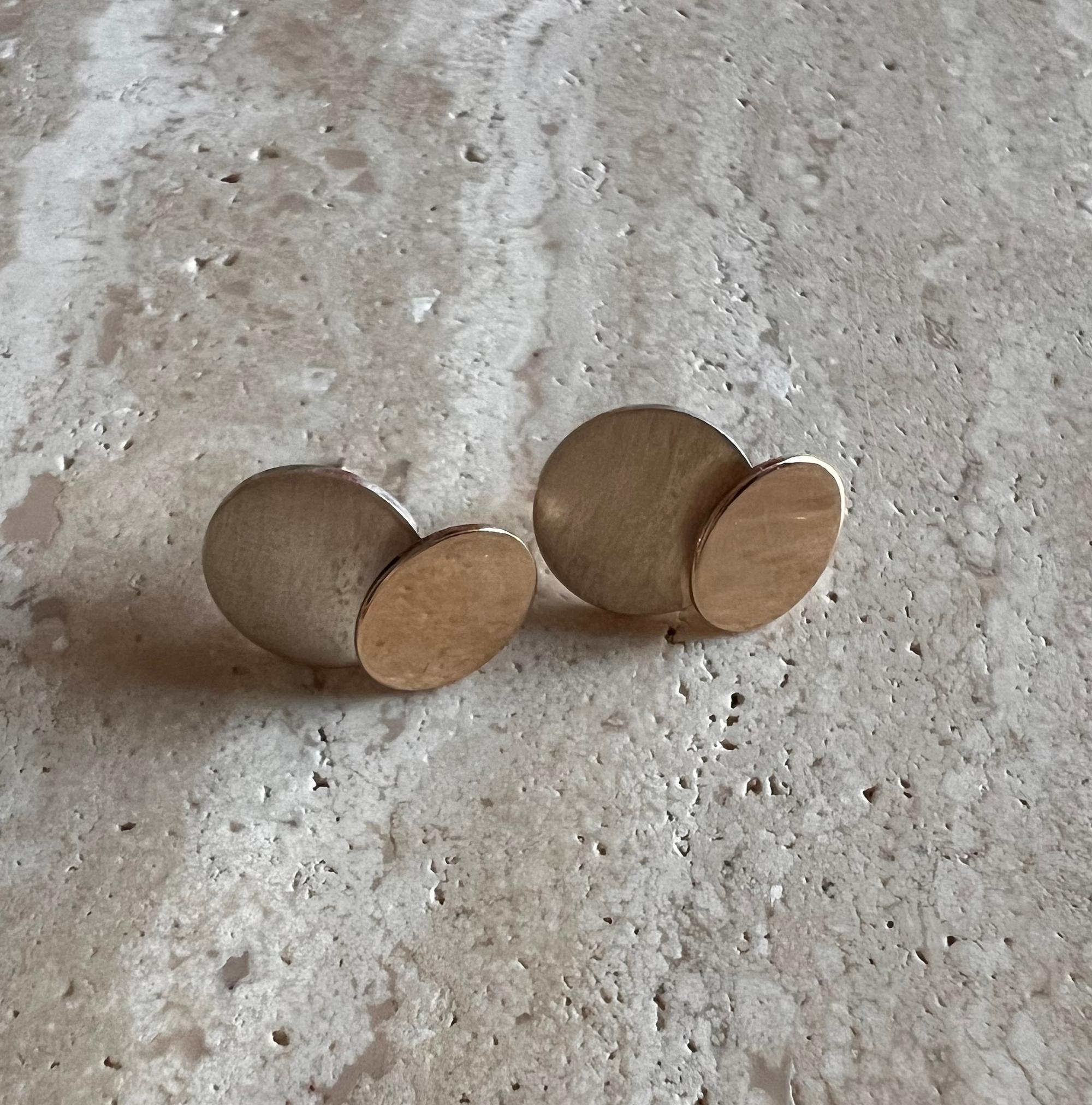 Timeless 14k gold and sterling silver earrings created by modernist jeweler Betty Cooke of Baltimore, Maryland.  Earrings are comprised of two circles or dots, one partially brushed sterling silver and the other 14k gold.  They measure 5/8
