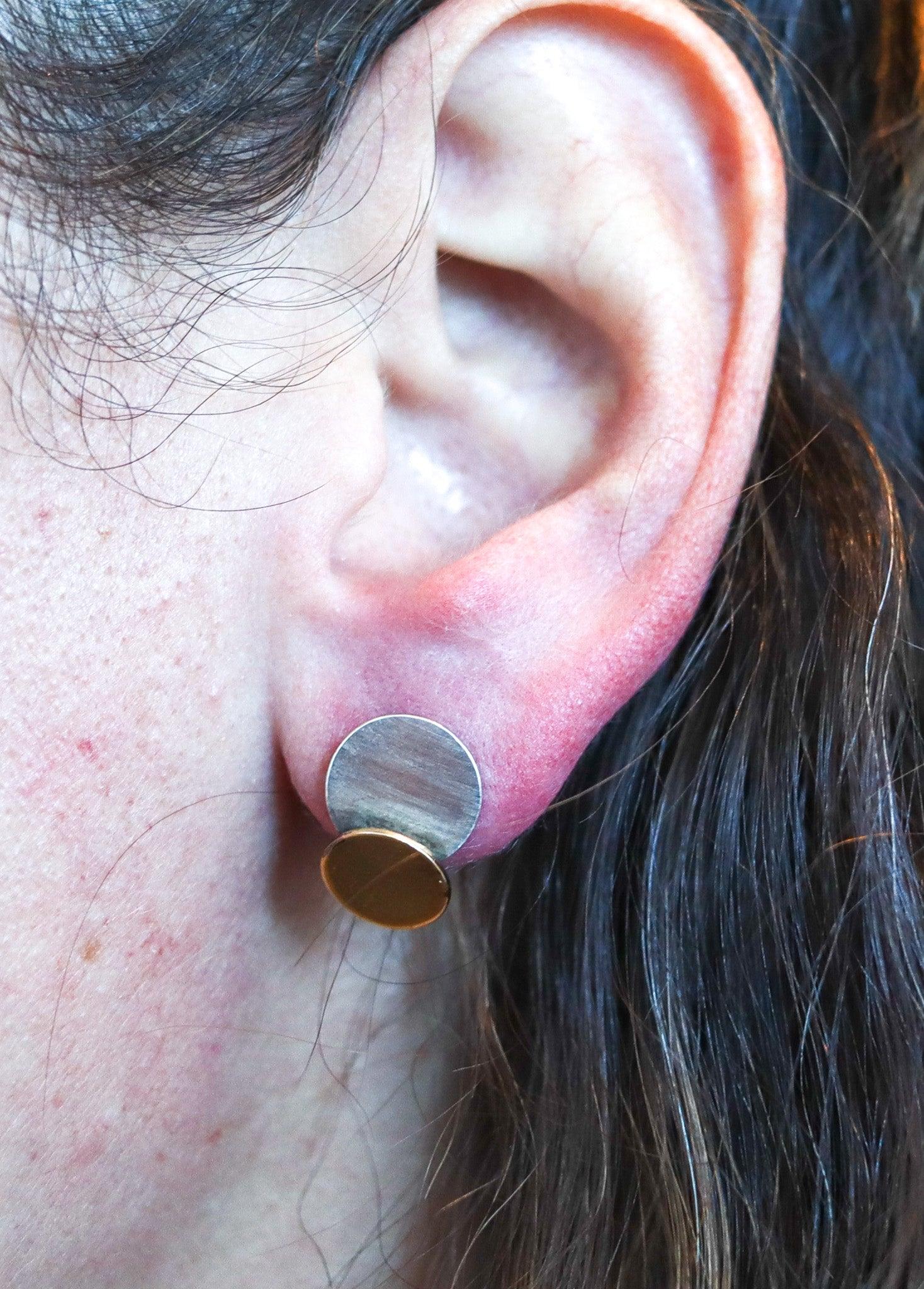 Geometric stud-earrings designed by Betty Cock. (1924-2025)

This is a great pair of geometric stud-earrings created by the artist-jeweler Betty Cooke. The sculptural earrings have been crafted with two circular elements, made up in solid yellow