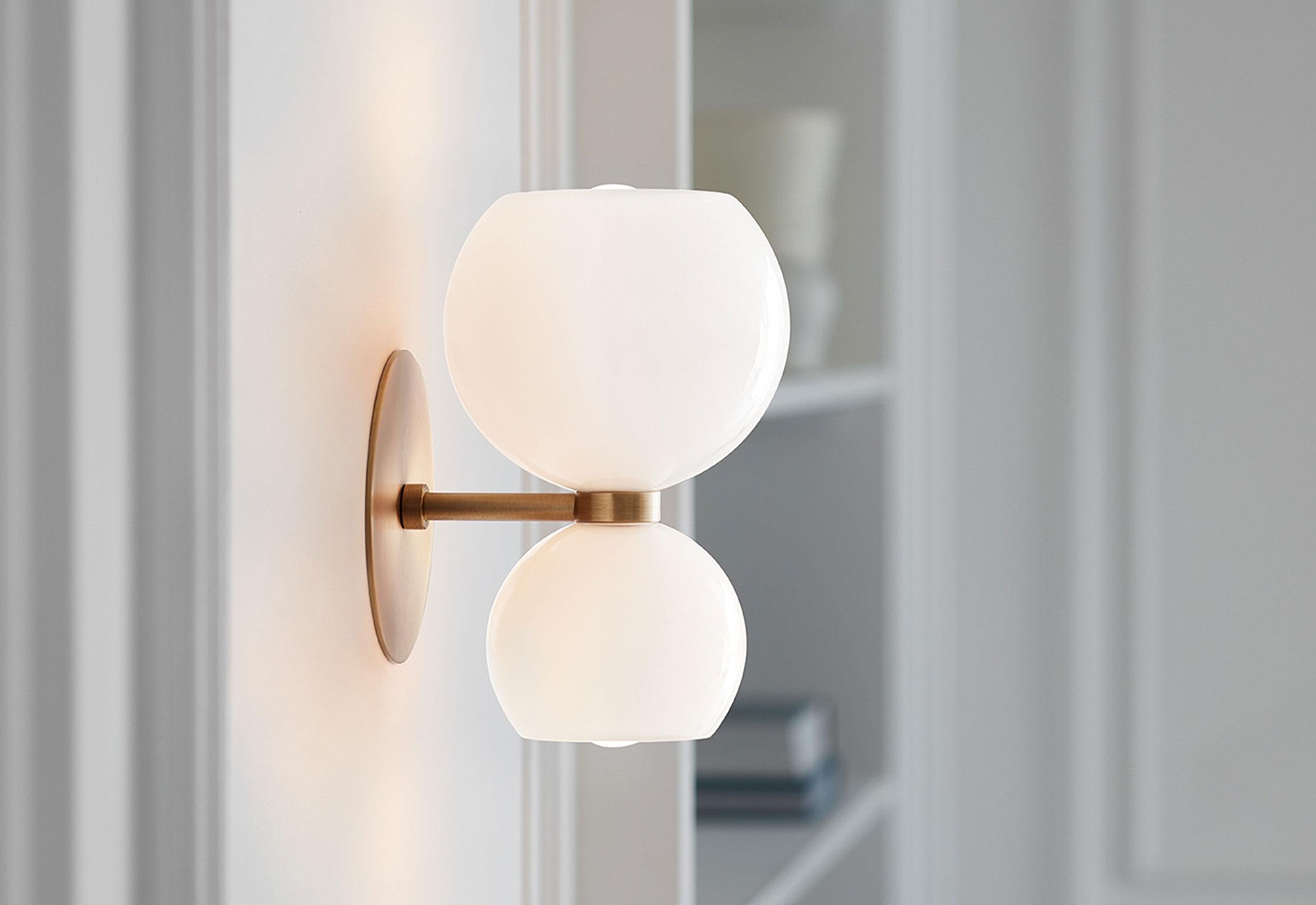 With curvaceous shapes and a nipped centre, Betty is a modern take on midcentury era design. Sculptural mold-blown glass spheres glow in opal opaque, semi-opaque colors or clear glass.

Betty is anchored by a cast brass back-plate finished in