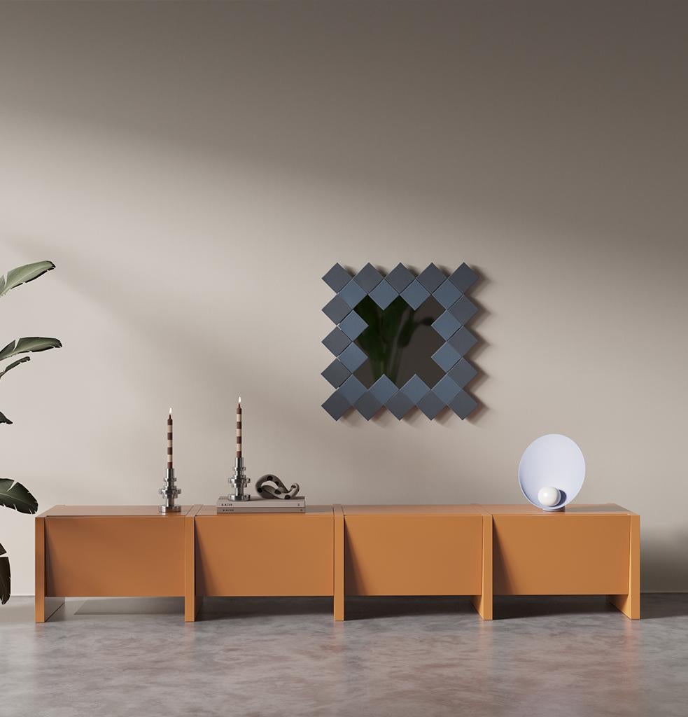 La consola baja Bisel, formada por módulos repetidos que se unen, tiene un aspecto contemporáneo con su diseño sencillo y sus líneas afiladas. La consola Bevel, con cuatro zonas de almacenamiento cubiertas, puede utilizarse como mueble de TV o como