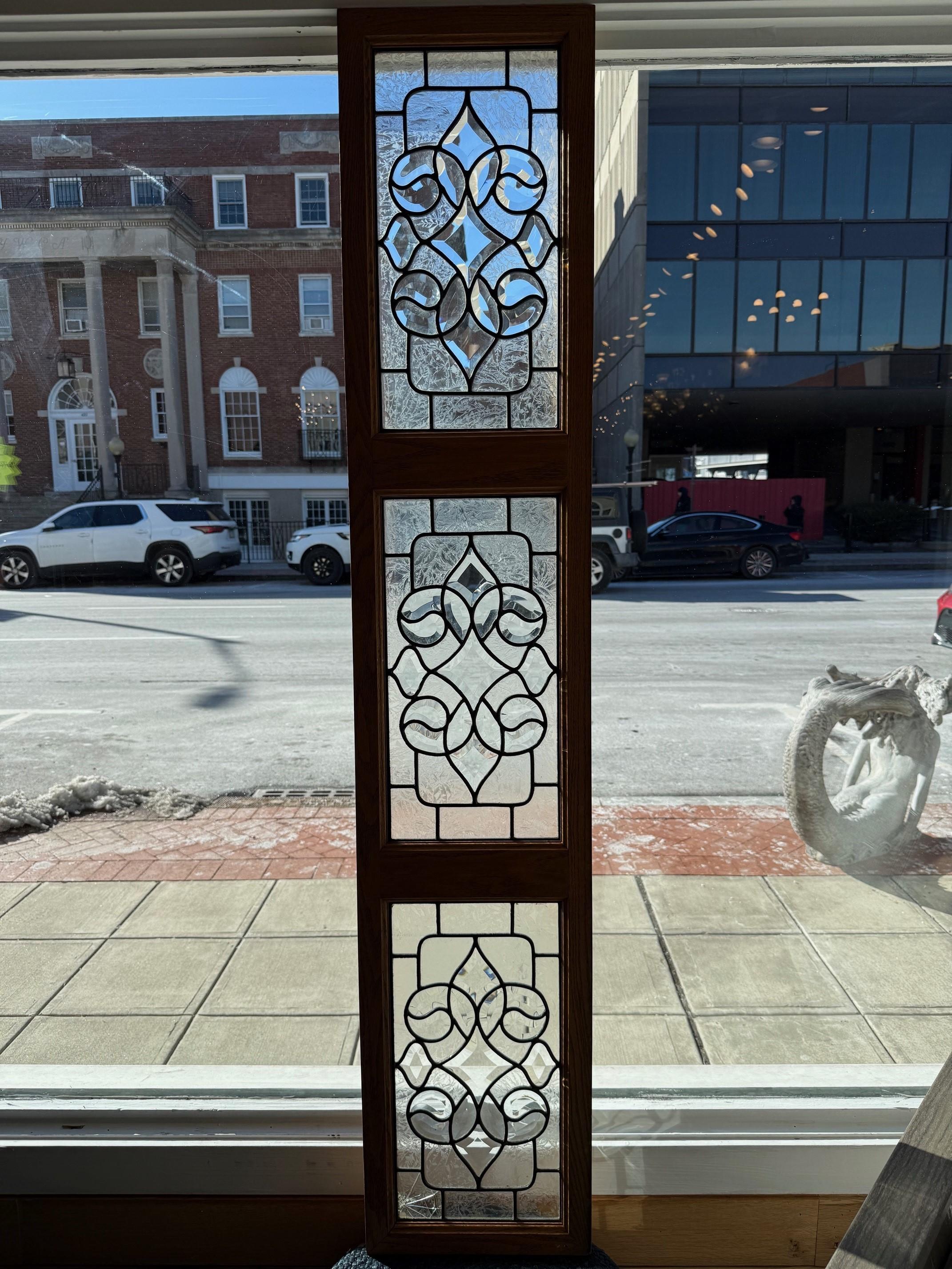 Late 20th Century beveled and etched glass transom with three panels in a custom oak frame. This is a nice piece with the combination of beveled and etched glass panels. The glass panels are reproductions from the late 80s early 90s. The panel can