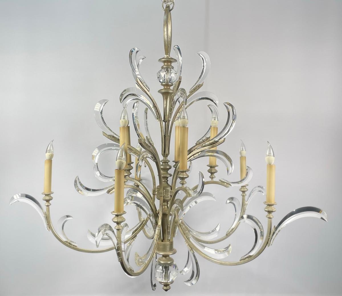 Introducing the stunning Beveled Arcs Chandelier by Fine Art Handcrafted Lighting - a true masterpiece of lighting design. This exquisite chandelier features ten lights, elegantly arranged amidst a shimmering silver frame. The beveled arcs of the