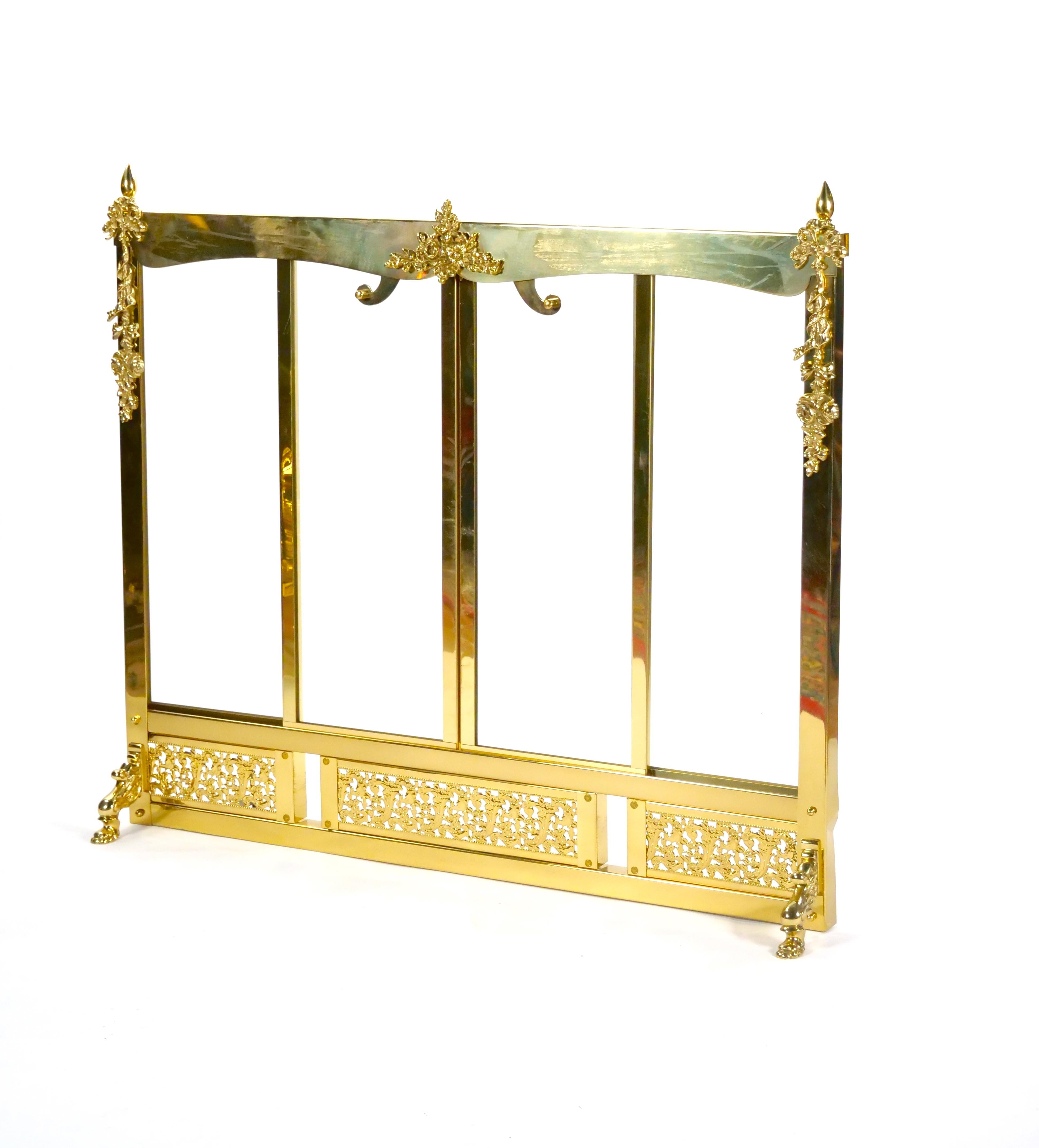 Aggiungi un tocco di raffinata eleganza al tuo focolare con questo eccezionale paravento per caminetto in vetro smussato e cornice in ottone. Questo pezzo di ottima fattura presenta un'intricata cornice in ottone con delicati dettagli decorativi,