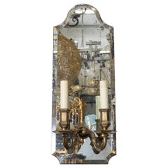 Beveled mirror and cast brass two-arm sconce
