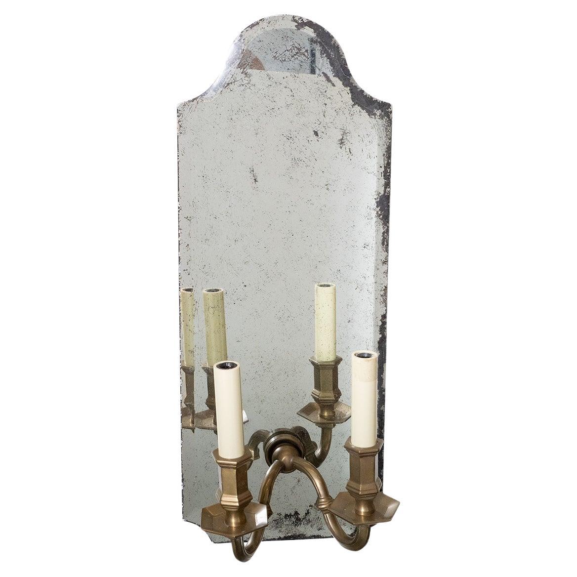 Beveled mirror and cast brass two-arm sconces