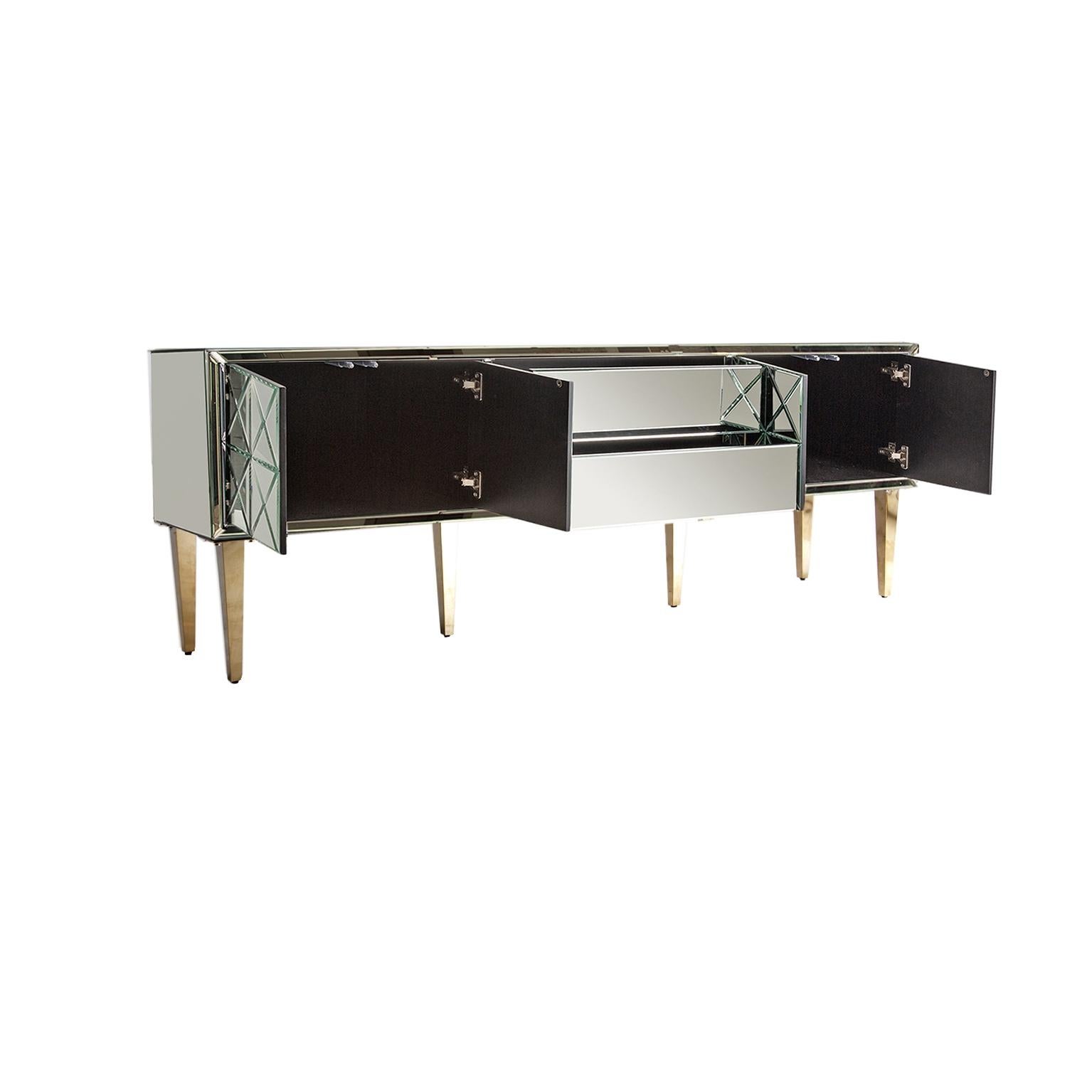 Sparkling and sophisticated mirrored sideboard with aerial gold metal feet four mirrored doors that and 2 central drawers.