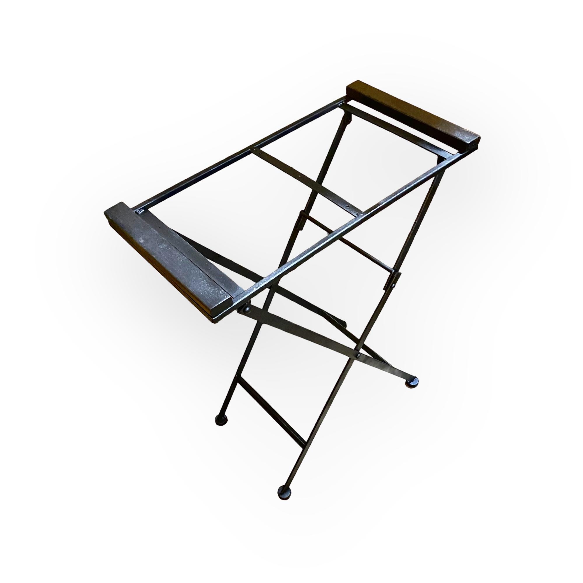 A 1970s beveled, mirrored drinks tray on an iron folding stand. Arrange your serving items in style with the portable butler tray table bar. This elegant piece offers space for glassware, nibbles and bottles of spirits or wine. It's made of iron
