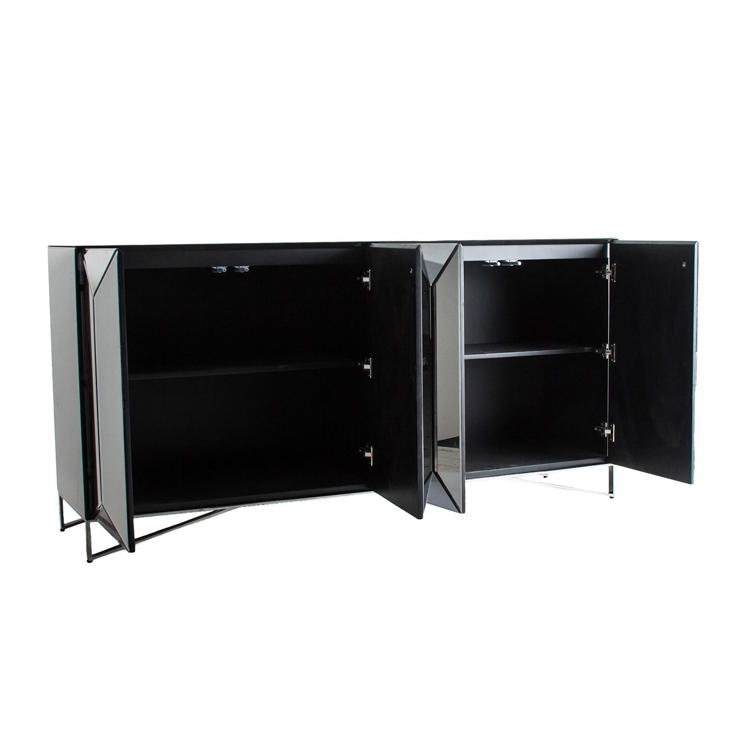 Sparkling and sophisticated mirrored sideboard with chrome feet four mirrored graphic panels doors opening on shelves.