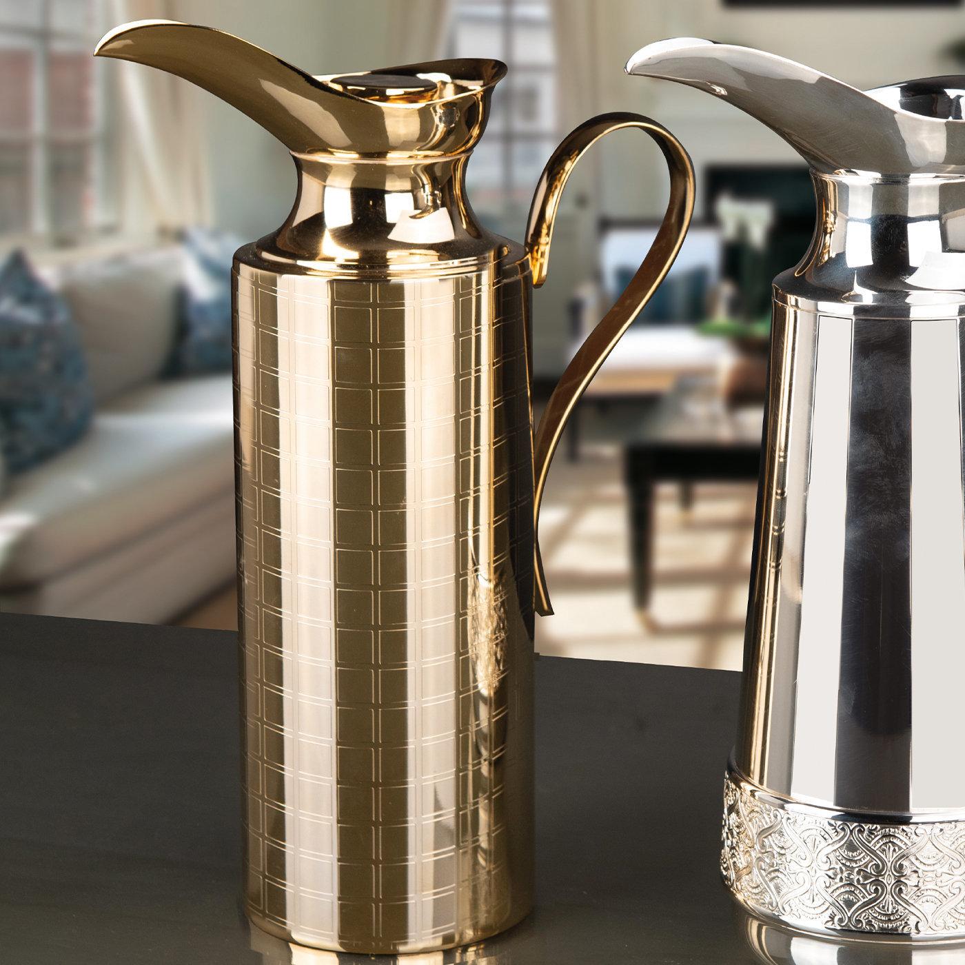 Entirely handcrafted of galvanized gold-finished brass, this spectacular pitcher will preciously adorn a dining table during a special occasion. Boasting a sleek, classic-inspired silhouette, it is interpreted in a modern key through an exquisite
