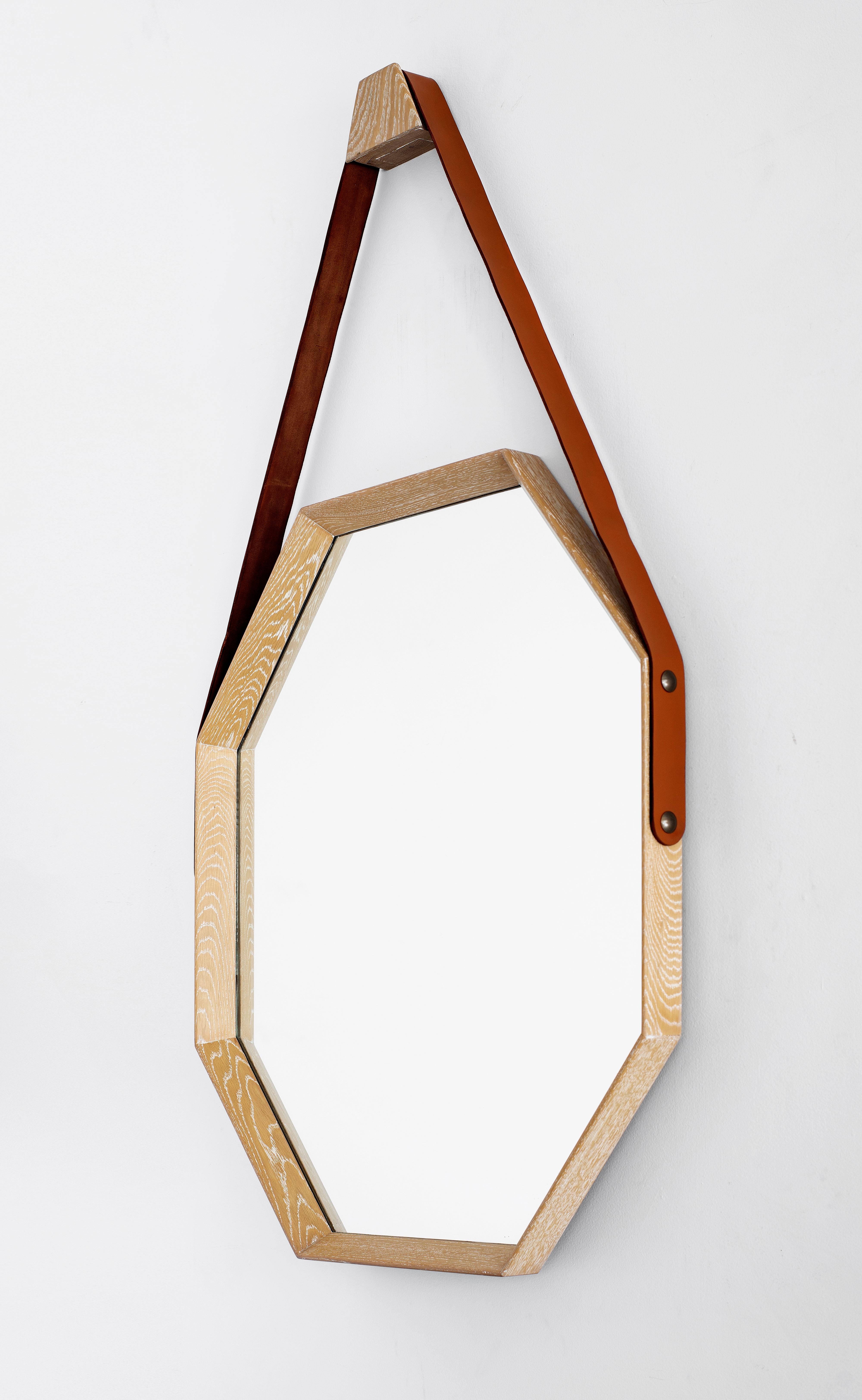 Newly produced by Orange, octagon shaped mirror with light Cerused wood finish and brown leather strap detail attached with brass studs. Multiple quantity and finishes available.

Mirror measures: 37.5