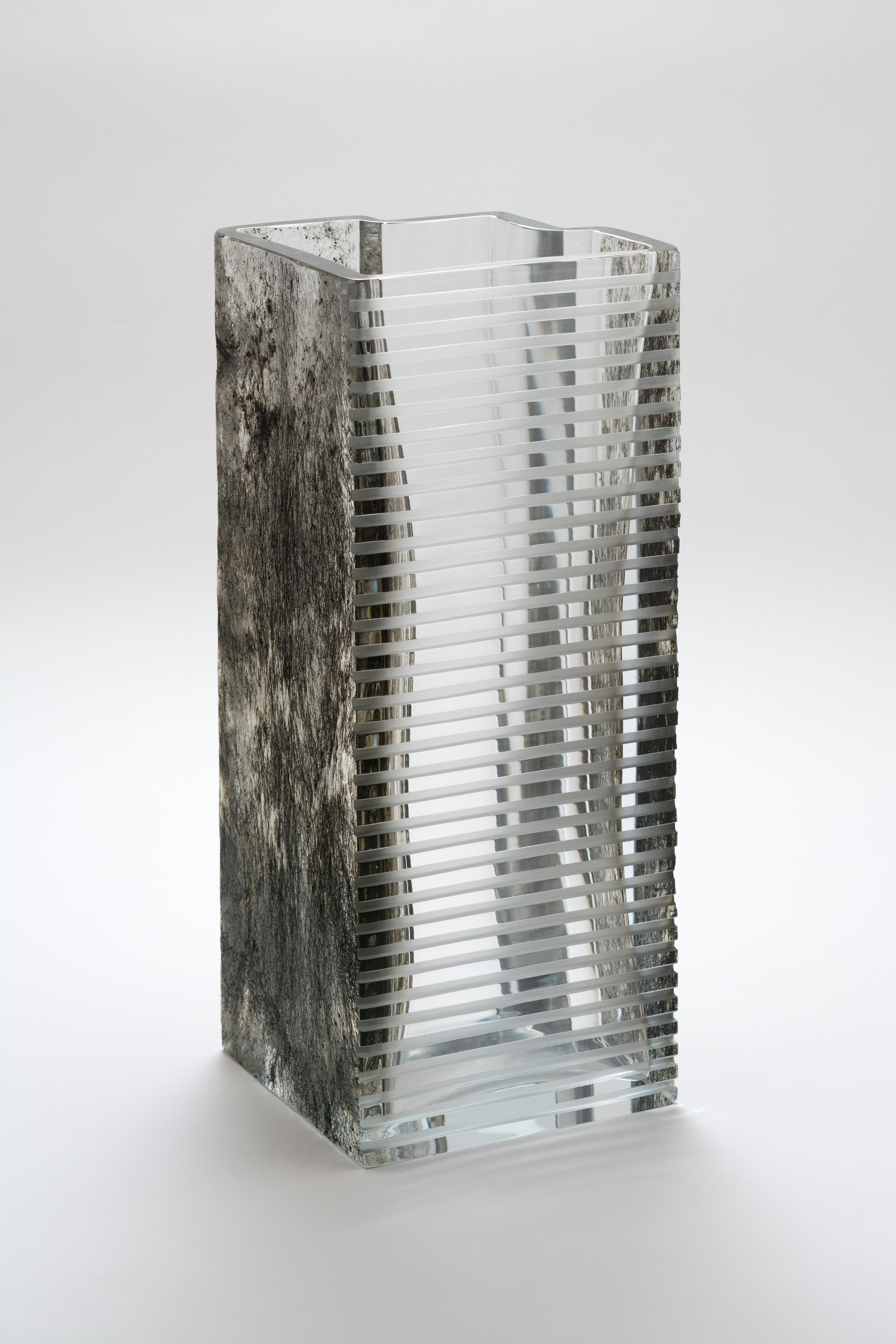 Vase Beyond the Dark Forest von Paolo Marcolongo
Abmessungen: 42 x 16,3 x H 17 cm 
MATERIALIEN: Murano-Glas und Eisen. 


Paolo Marcolongo wurde 1956 in Padua geboren, er besuchte das Kunstgymnasium 