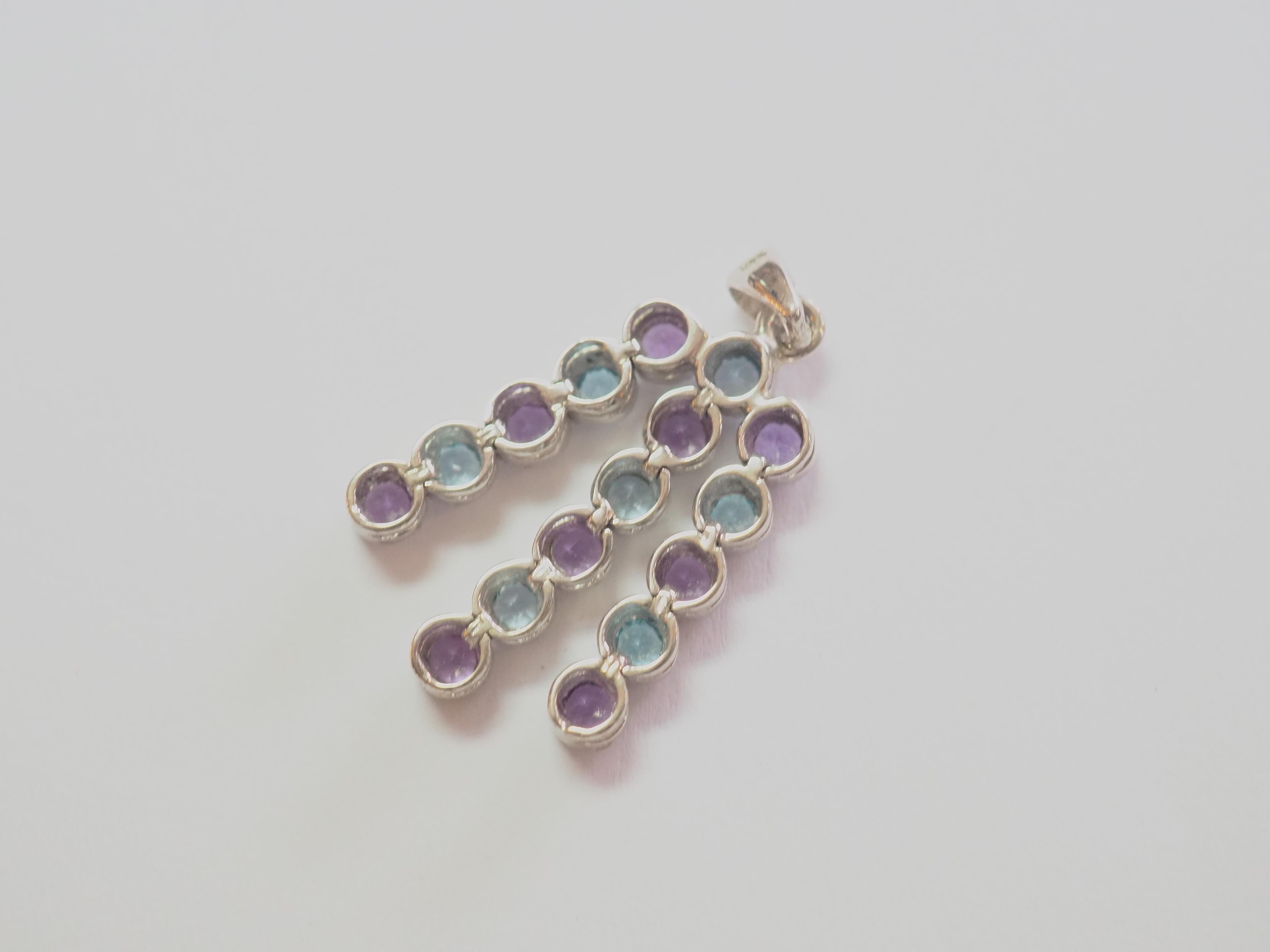 A very beautiful and delicate dangling pendant in sterling silver for wearing everyday. The pendant includes 7 round blue topaz and 9 round purple amethysts set in bezel and arranged masterfully. The piece is made in the early turn of the century