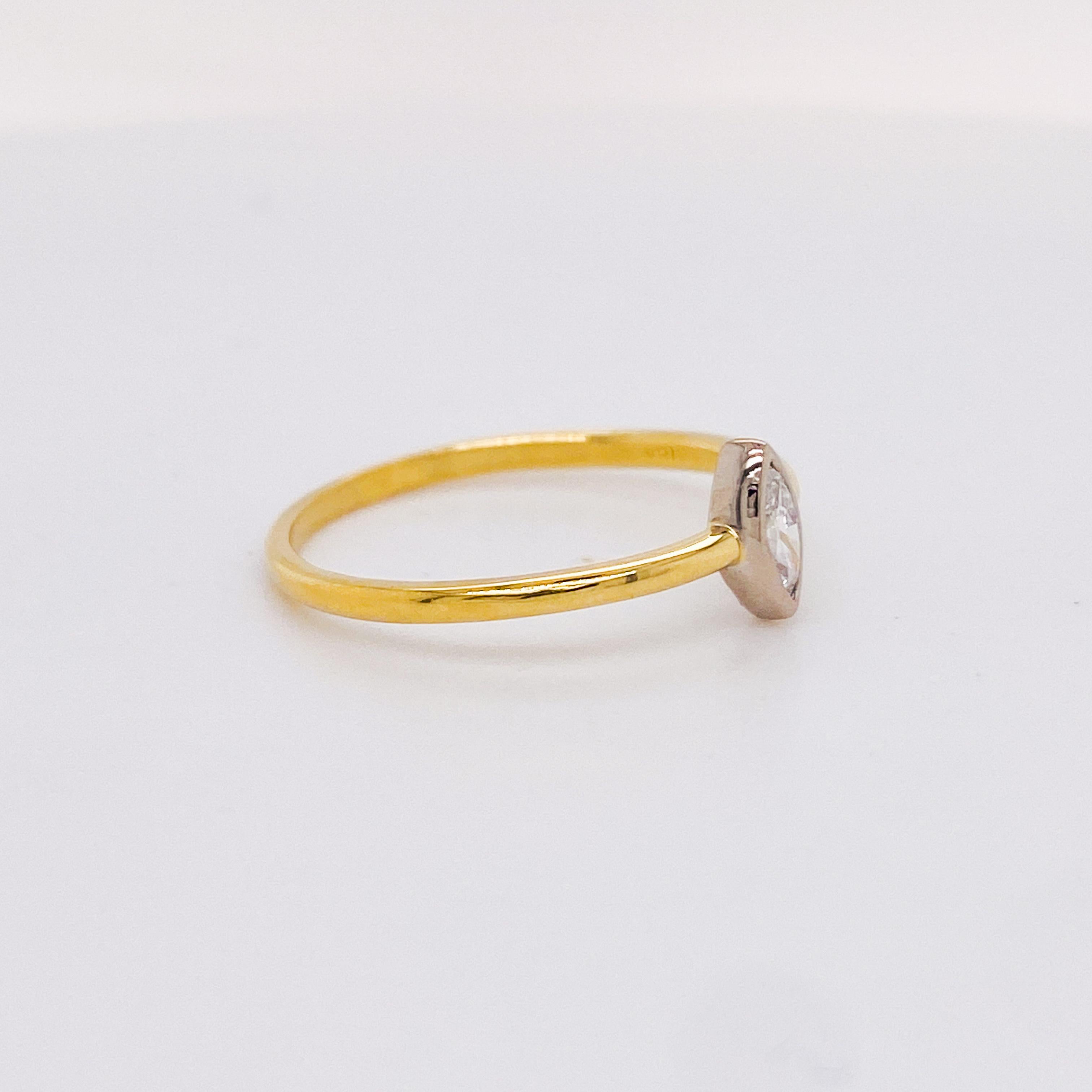 This minimalist marquise diamond ring holds a 0.25 carat marquise diamond in an 18 karat white gold bezel. The marquise diamond is SI clarity and G color (near colorless). The 18 karat yellow gold band is made with smooth round gold wire making for