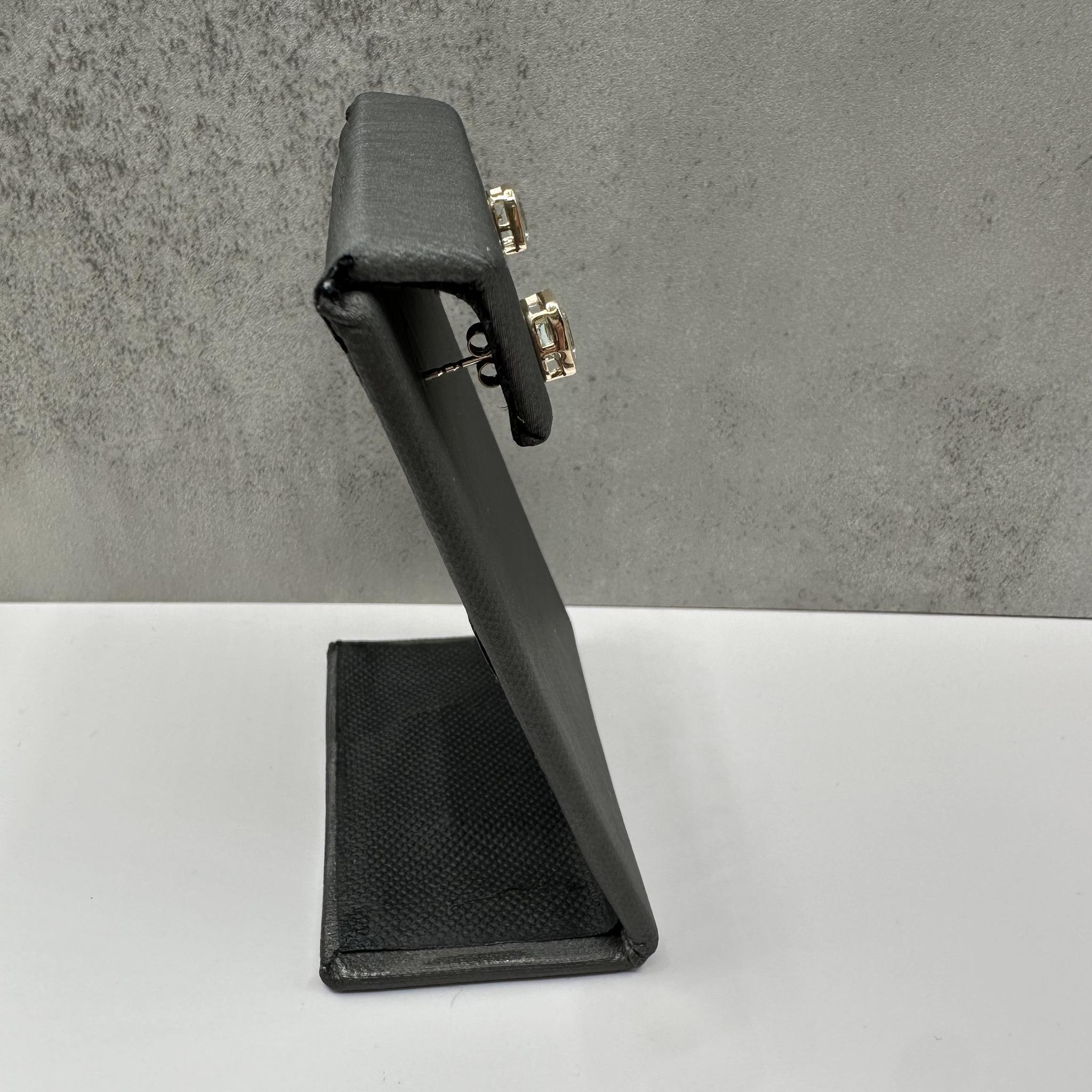 Ces élégantes boucles d'oreilles en or jaune 10 carats serties d'aigue-marine présentent des aigues-marines naturelles de taille émeraude d'environ 6 x 4 mm, mettant magnifiquement en valeur leur teinte bleue sereine. La lunette offre un look