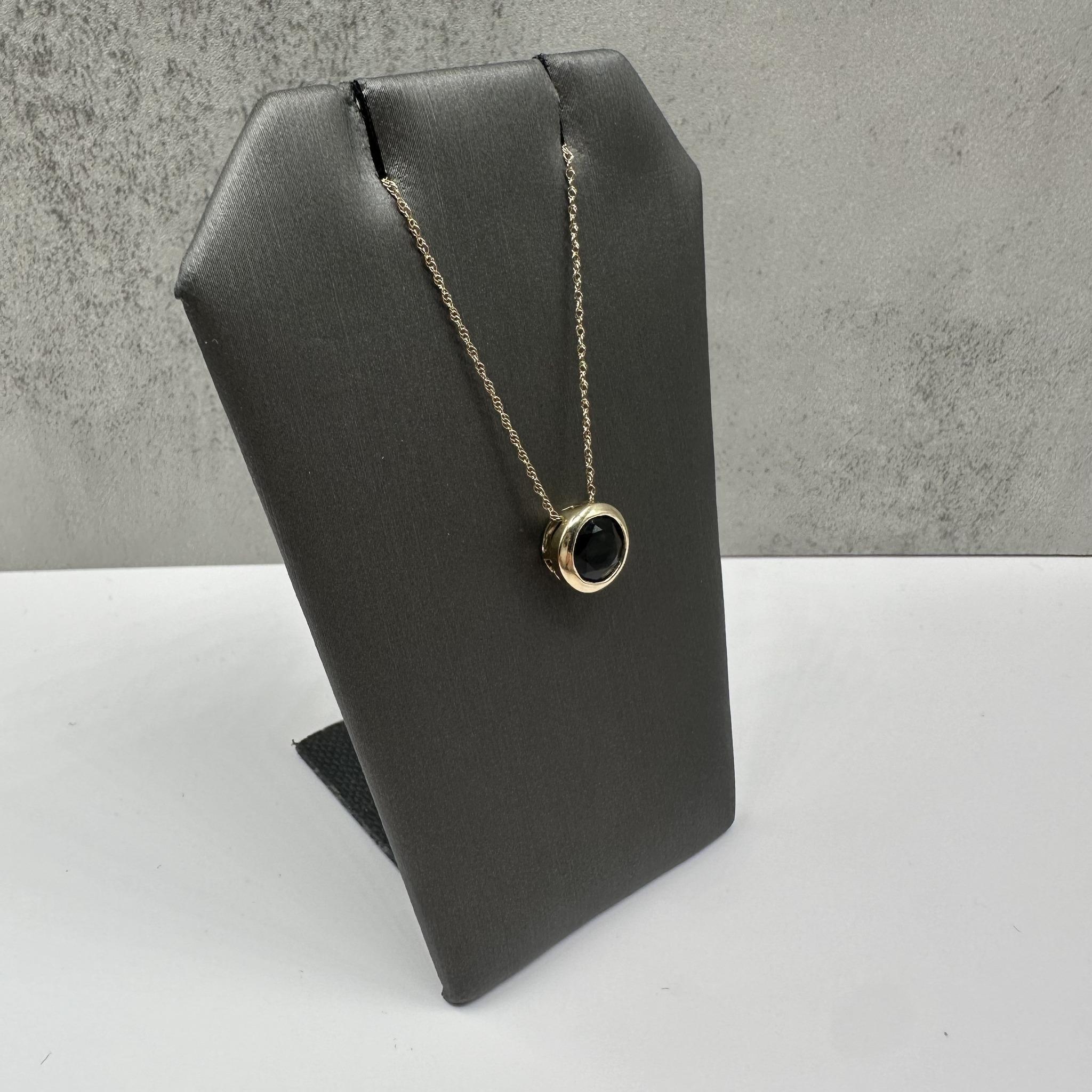 Questa elegante collana con onice nero incastonato in oro giallo 10 carati è caratterizzata da un onice nero rotondo di circa 8 mm che conferisce un'eleganza audace a qualsiasi abbigliamento. Con una lunghezza di 18 pollici e una sicura chiusura ad