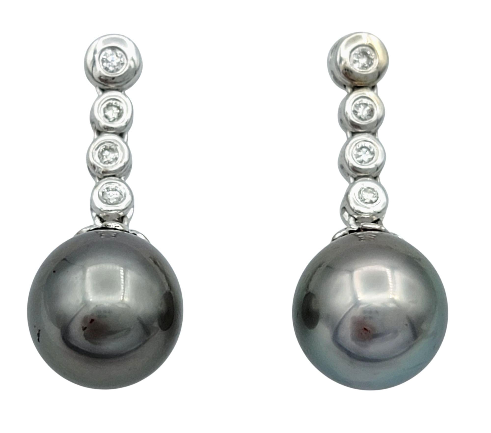 Gracefully elegant, these freshwater black pearl and diamond earrings bring a touch of refined luxury to any look. Each earring features a lustrous round freshwater pearl suspended from a vertical row of brilliant-cut diamonds that add sparkle and
