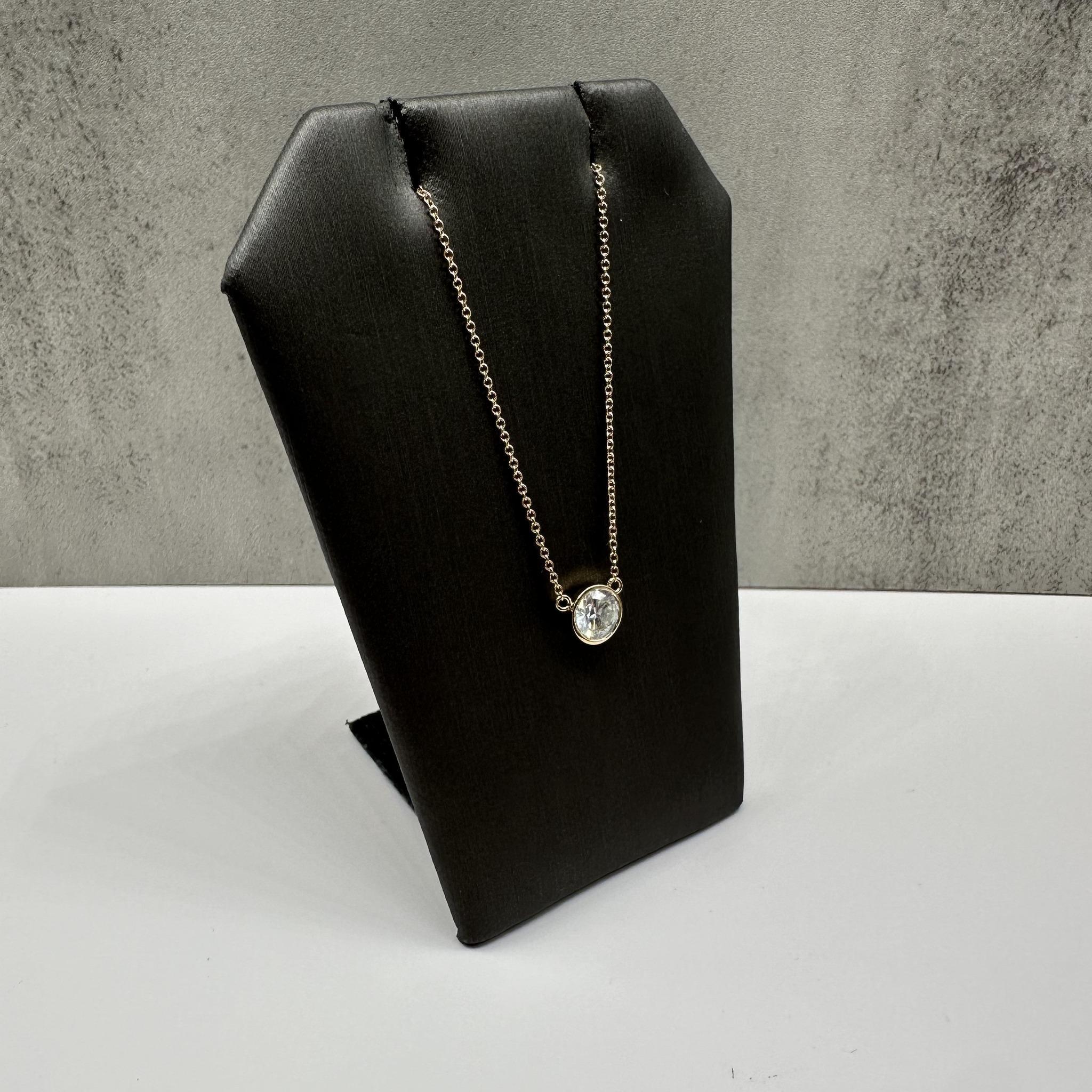 Cet élégant collier en or jaune 14kt serti de diamants présente un diamant rond naturel G I1 de 0,72 carat certifié par le GIA pour une garantie d'authenticité et de qualité. La lunette lisse offre un aspect moderne et raffiné tout en mettant en