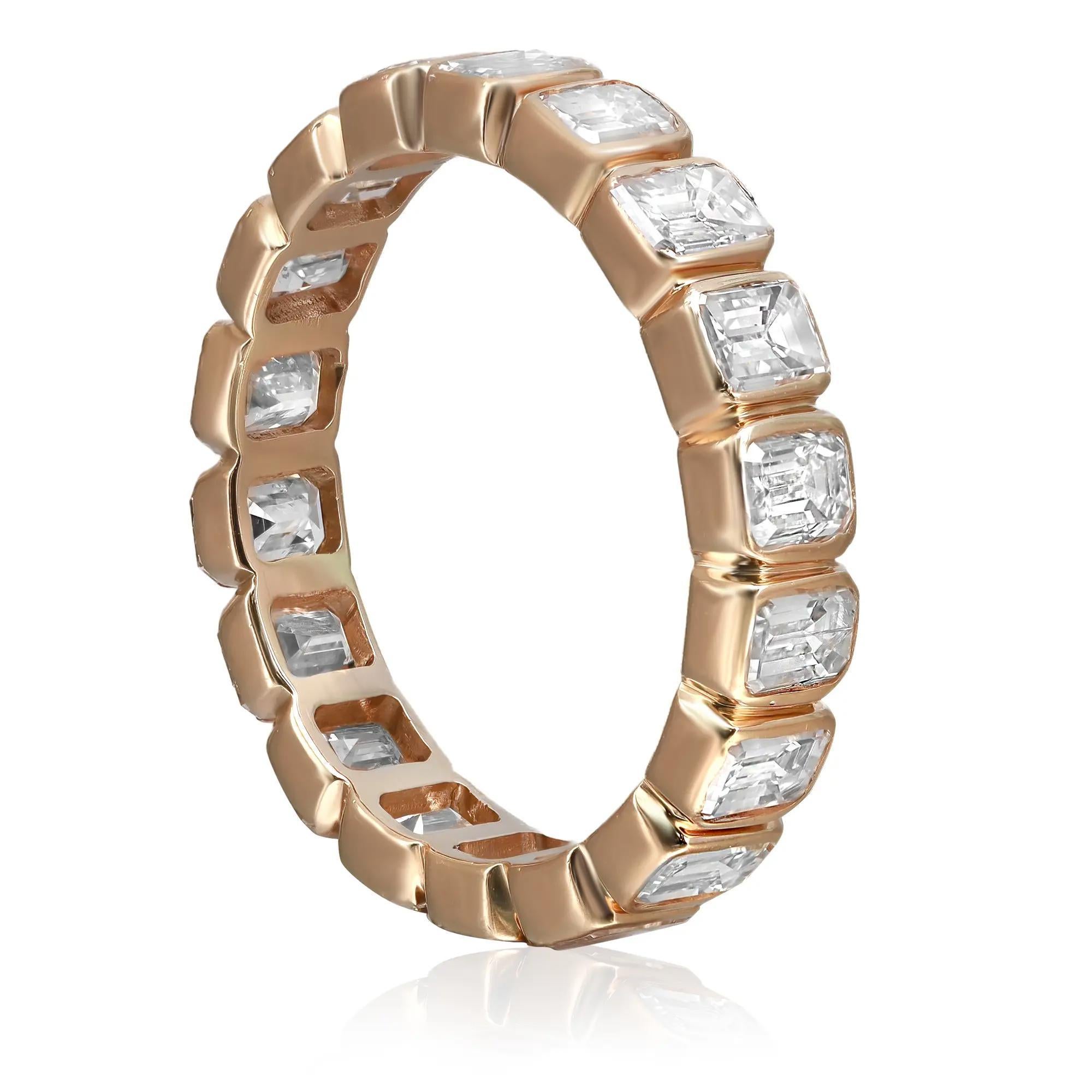 Shimmering and elegant, this statement wedding eternity band ring is crafted in lustrous 14K yellow gold and features 18 bezel set dazzling emerald cut diamonds weighing 3.35 carats. Diamond quality: G-H and clarity VS-SI. Super stackable and