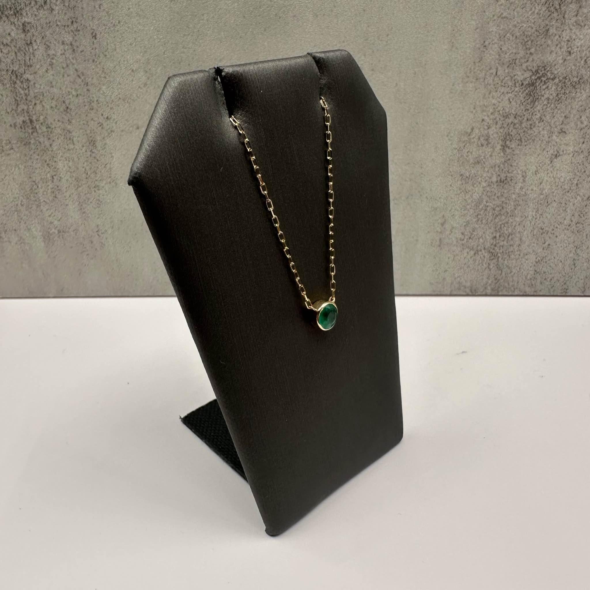 Questa elegante collana con smeraldo incastonato in oro giallo 14kt presenta uno smeraldo rotondo da 0,55 carati incastonato in un castone sicuro, che offre un vibrante tocco di colore. Con un peso di 1,6 grammi e una lunghezza regolabile da 16 a 18