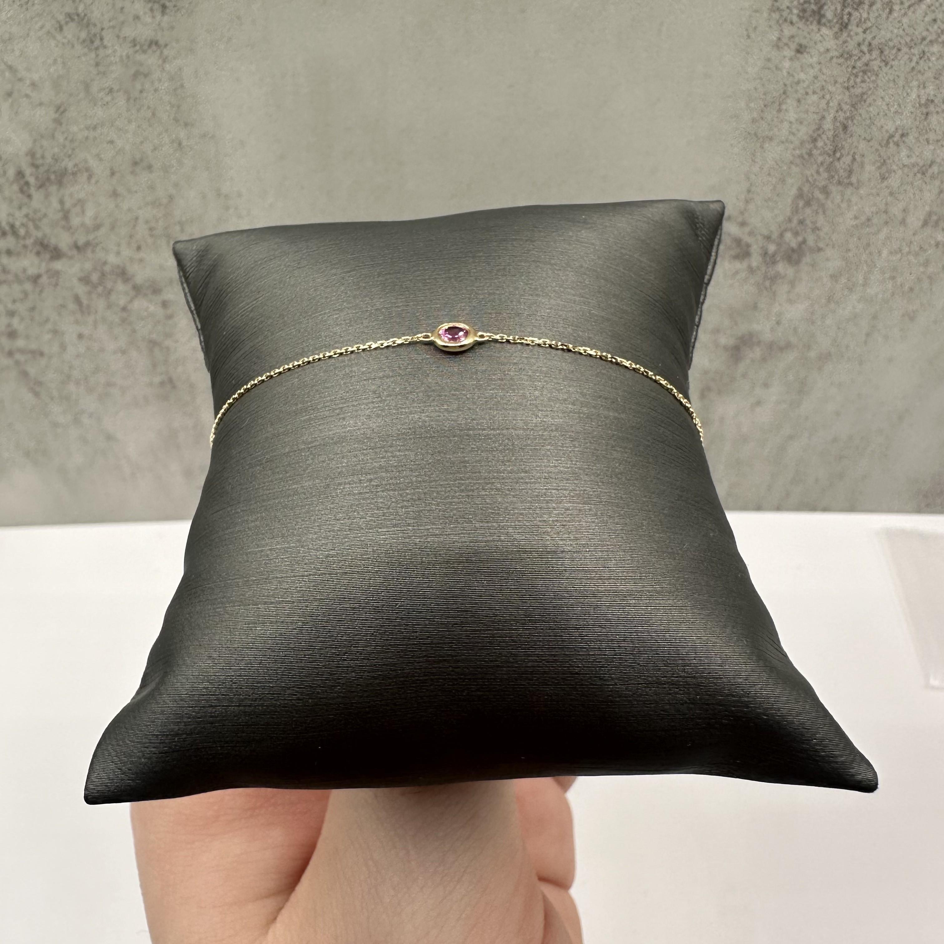 This elegant Bezel Set Gemstone Bracelet in 14kt yellow gold features 0.12ctw of round pink tourmaline gemstones, adding a vibrant pop of color. The length is adjustable between 6 and 7 inches, offering versatility for different wrist sizes.