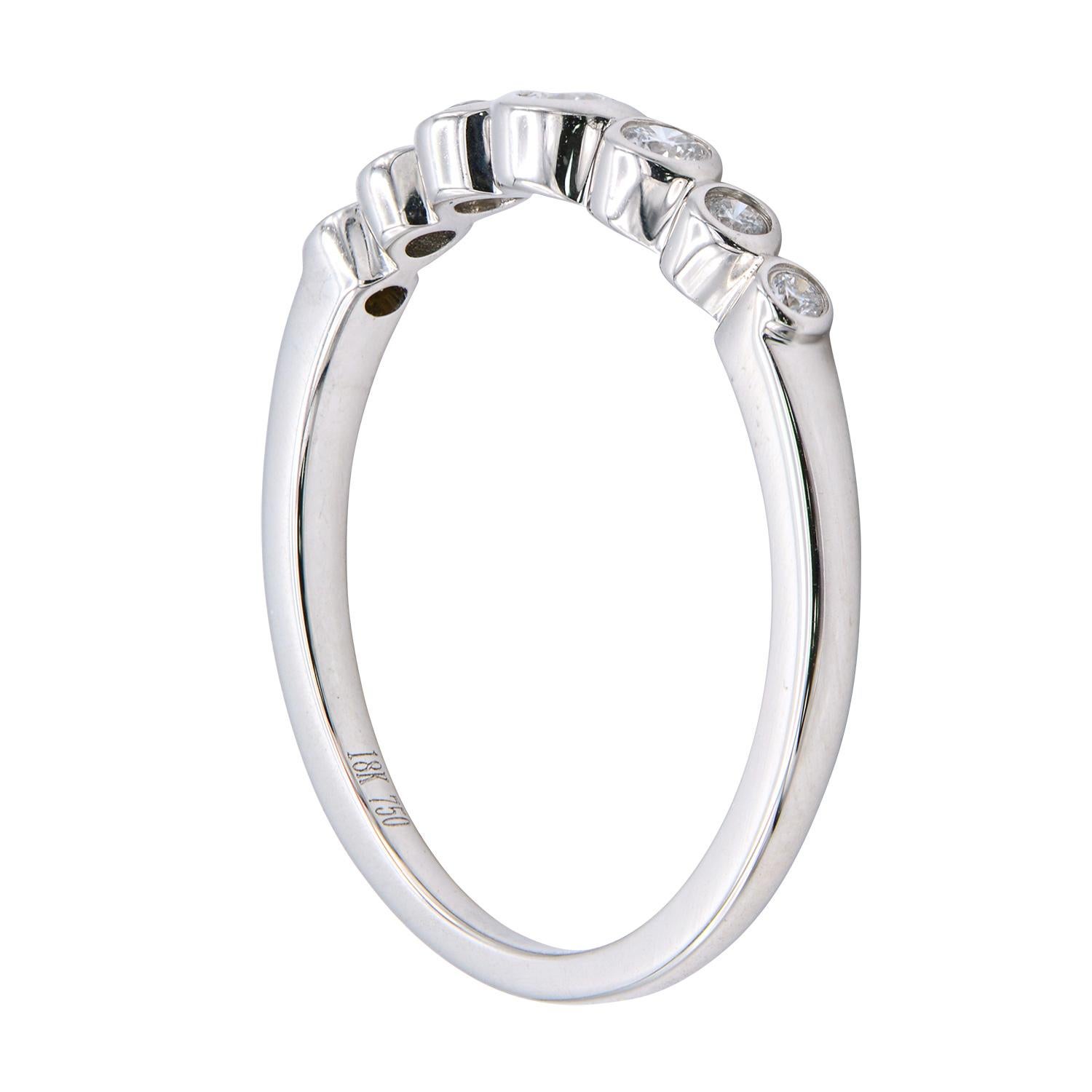 This beautiful ring contains 7 diamonds that are graduated towards the center diamond. They are VS2, G color and total 0.16 carats. They are set in a bezel style in 18 karat white gold totaling 2.1 grams. This classic ring is simple and elegant and