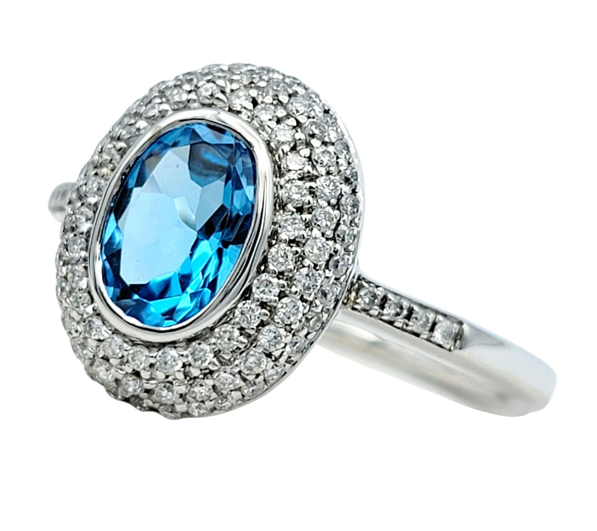 Ringgröße: 7

Dieser exquisite Ring ist eine atemberaubende Mischung aus Brillanz und Raffinesse. In seiner Mitte befindet sich ein lebhafter Blautopas im Ovalschliff, der in fesselnden ozeanischen Blautönen erstrahlt. Der Edelstein wird von einem