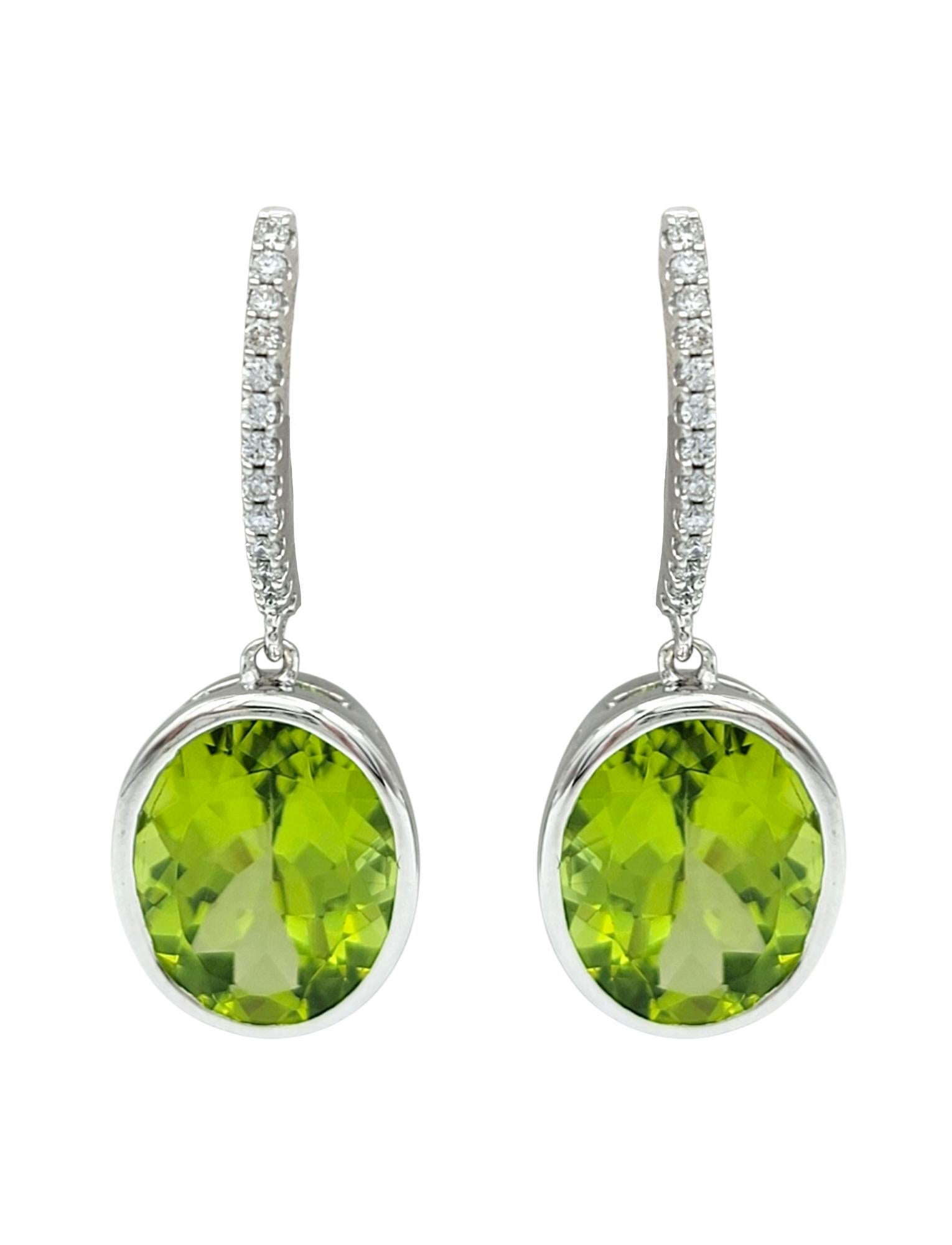 Contemporary Bezel Set Oval Cut Peridot Dangle Earrings with Diamonds in 14 Karat White Gold For Sale