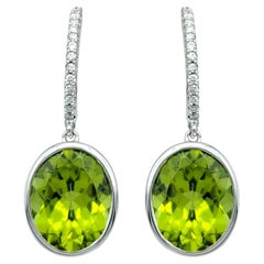 Bezel Set Oval Cut Peridot Dangle Earrings with Diamonds in 14 Karat White Gold