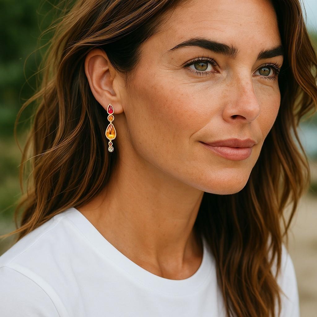 Introducing an exquisite pair of handcrafted drop earrings, a true testament to luxury and sophistication. Meticulously crafted from 14 Karat Yellow Gold, these elegant earrings feature an alluring blend of precious gemstones, creating a timeless