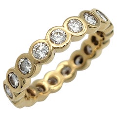 Anillo de eternidad de oro amarillo de 14 quilates con diamantes redondos talla brillante engastados en bisel