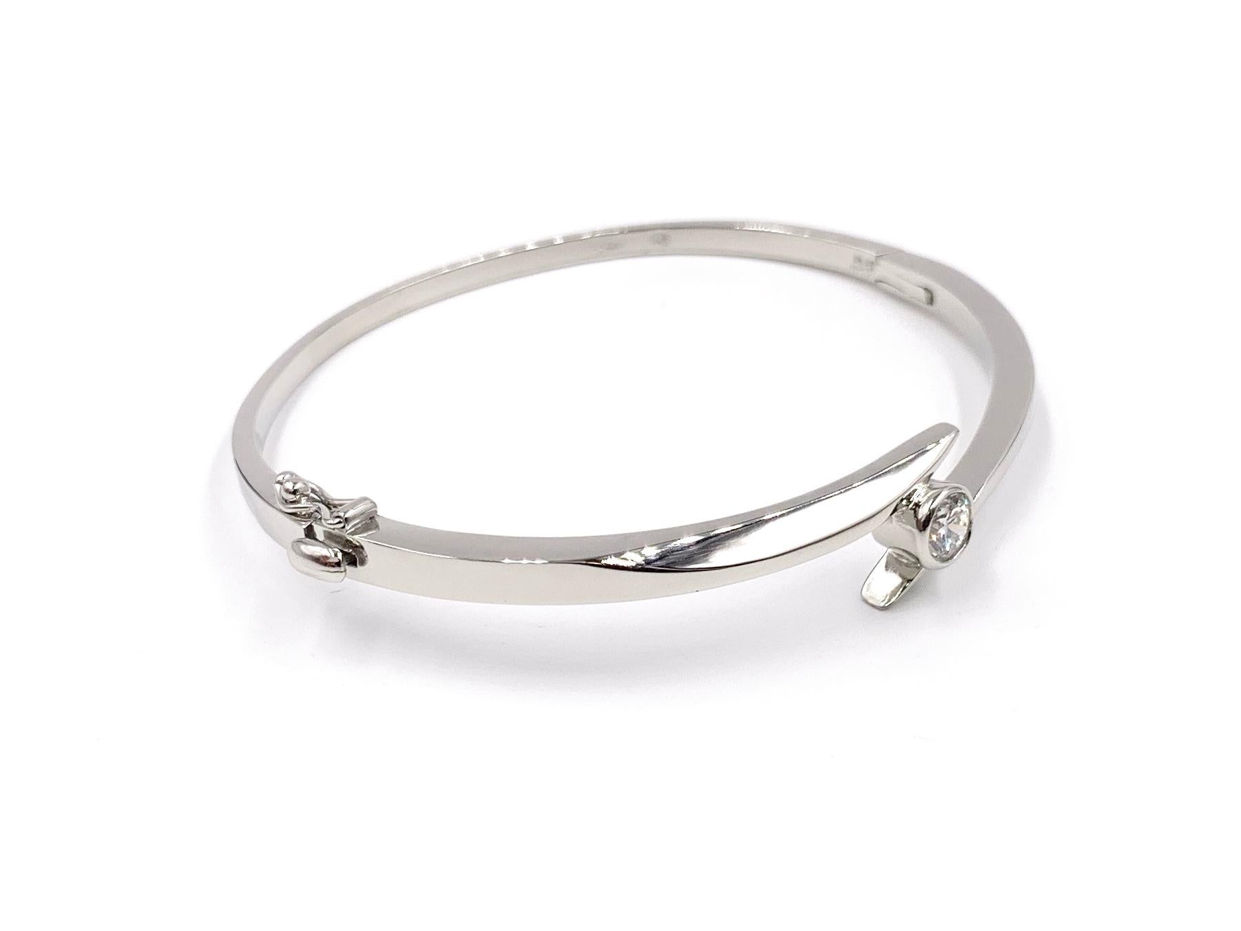 Great for stacking or wearing by itself! A wearable and classic polished platinum bangle bracelet featuring an approximate .50 carat round brilliant diamond at approximately G color, SI1 clarity (eye clean). Bangle is fitted with a push-button clasp