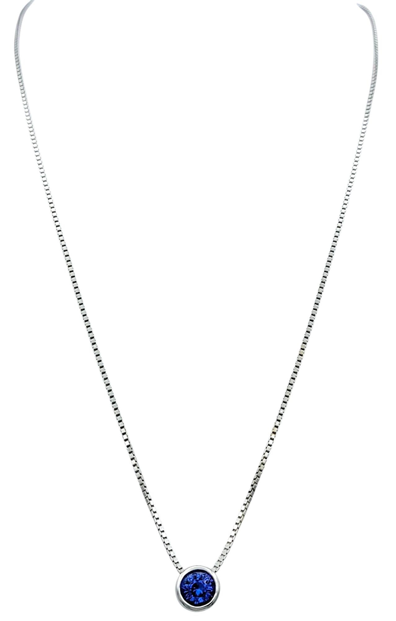 A stunning showcase of elegance, this pendant necklace features a vibrant round-cut tanzanite set in a sleek bezel of 14 karat white gold. The solitaire tanzanite radiates a blue-violet hue, offering a refined pop of color against the polished white