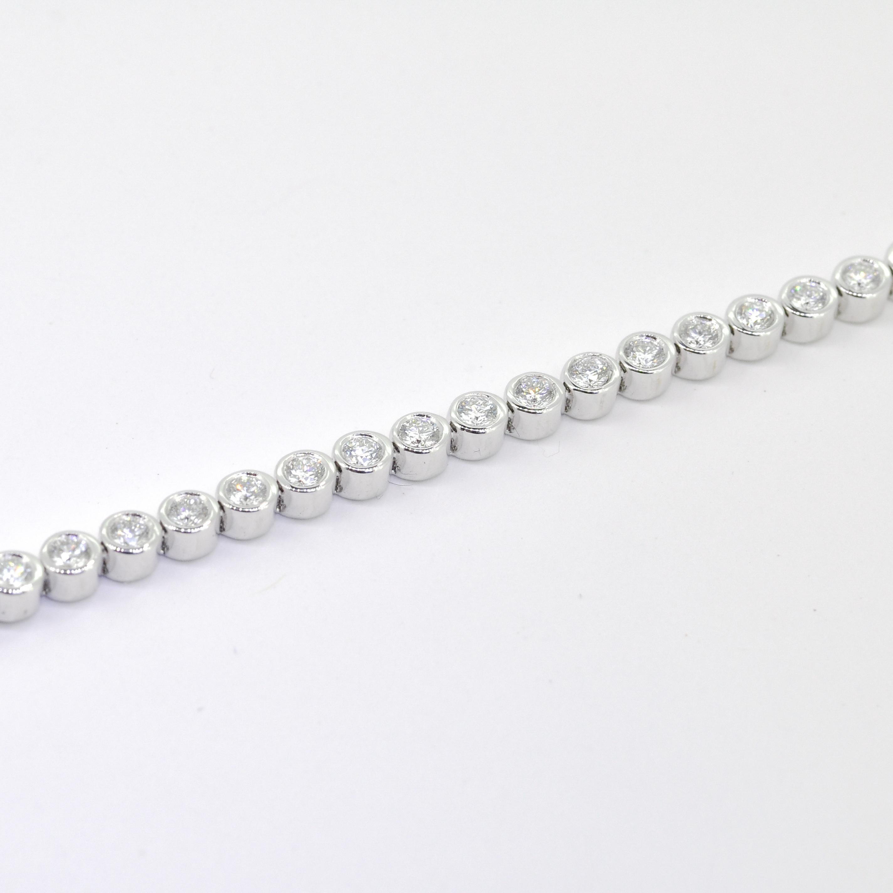 Step into the realm of timeless elegance with this classic bezel-set tennis bracelet. Meticulously crafted in 18K white gold, this exquisite piece showcases the allure of 4.00 carats of natural diamonds. Each diamond is elegantly encased within a