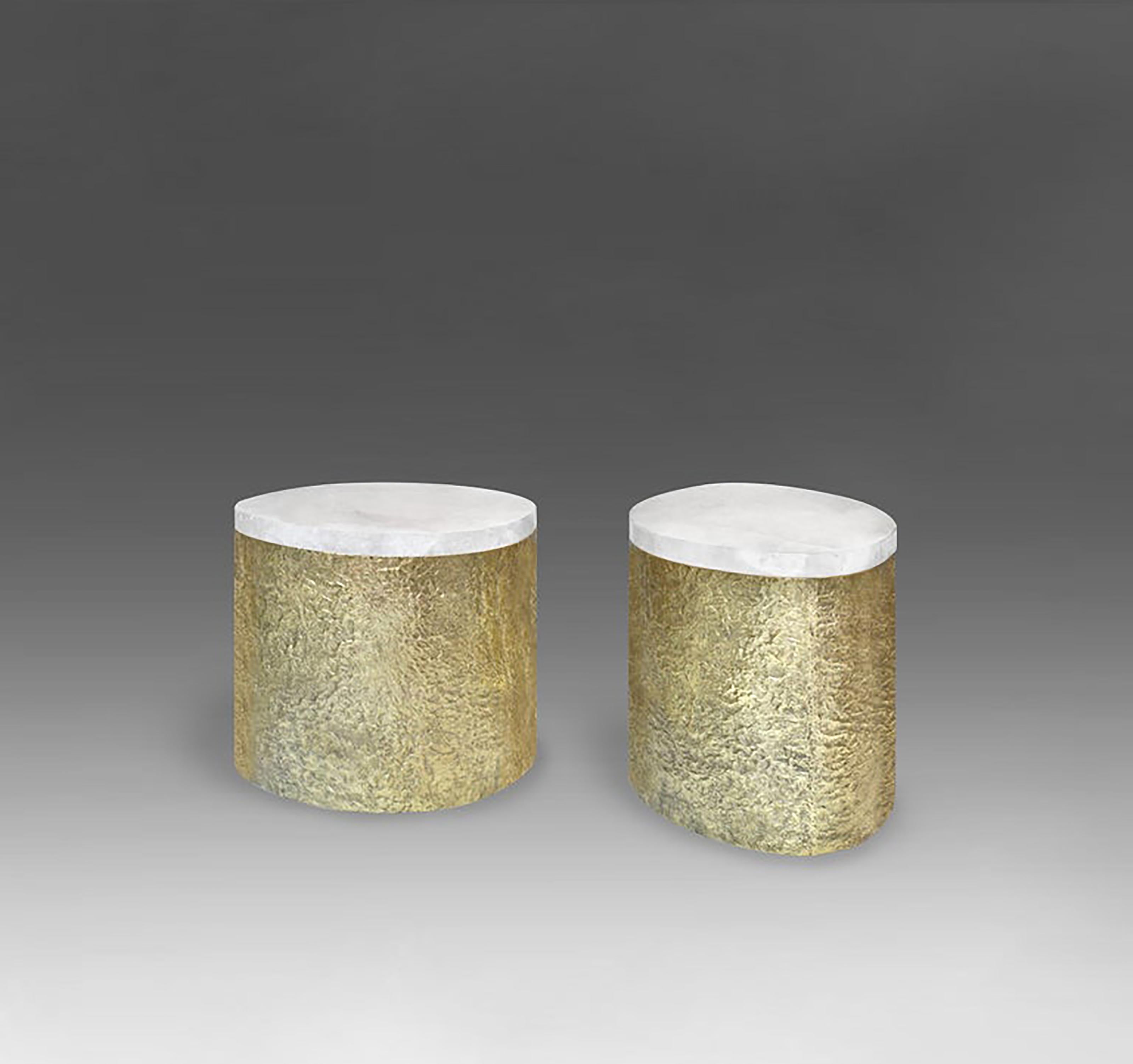 Pair of oval form rock crystal cocktail tables with the hammered brass bases. Created by Phoenix Gallery, NYC.