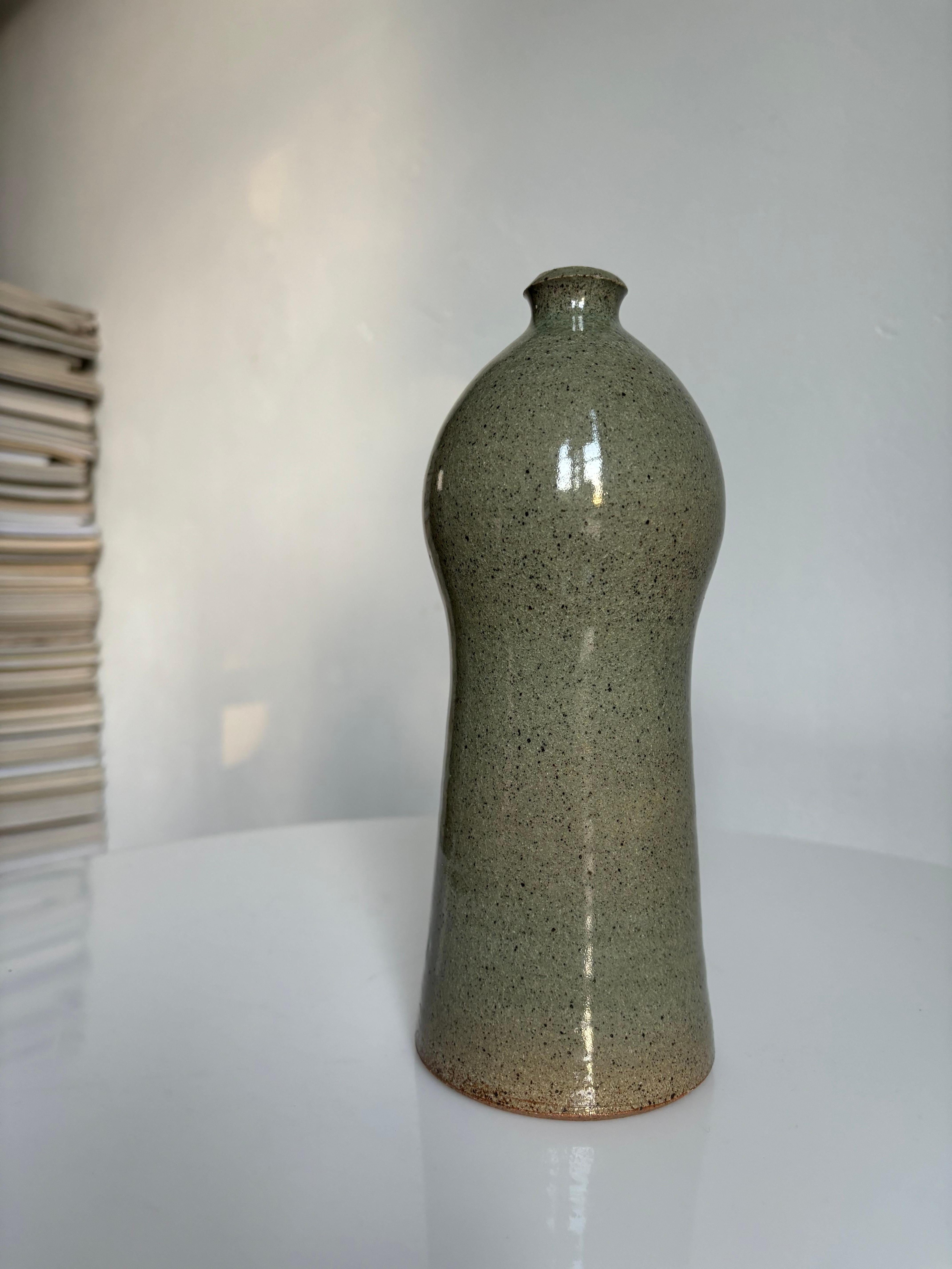 Curvy and slender handmade ceramic vase with narrow opening. By designer Ole Bøgild for Lee Keramik in the 1970s. Glazed with a beautifully speckled sage green shiny glaze. Signed under base. Beautiful vintage condition. 
Denmark, 1970s. 