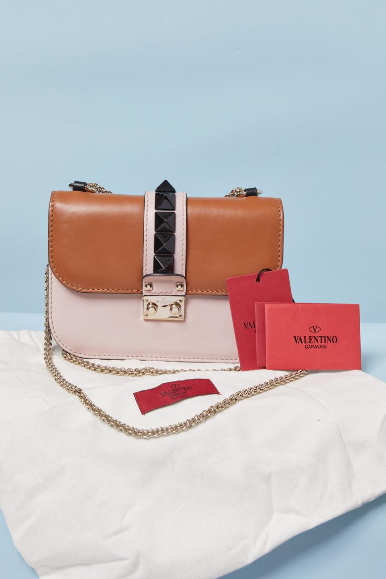 Sac en cuir bicolore avec clous noirs. Doublure en cuir noir. Fermeture à fermoir sur le milieu de la partie supérieure. 2 poches intérieures (une intérieure avec fermeture éclair, une plate sans). Sac à poussière fourni. Une poche plate au dos.