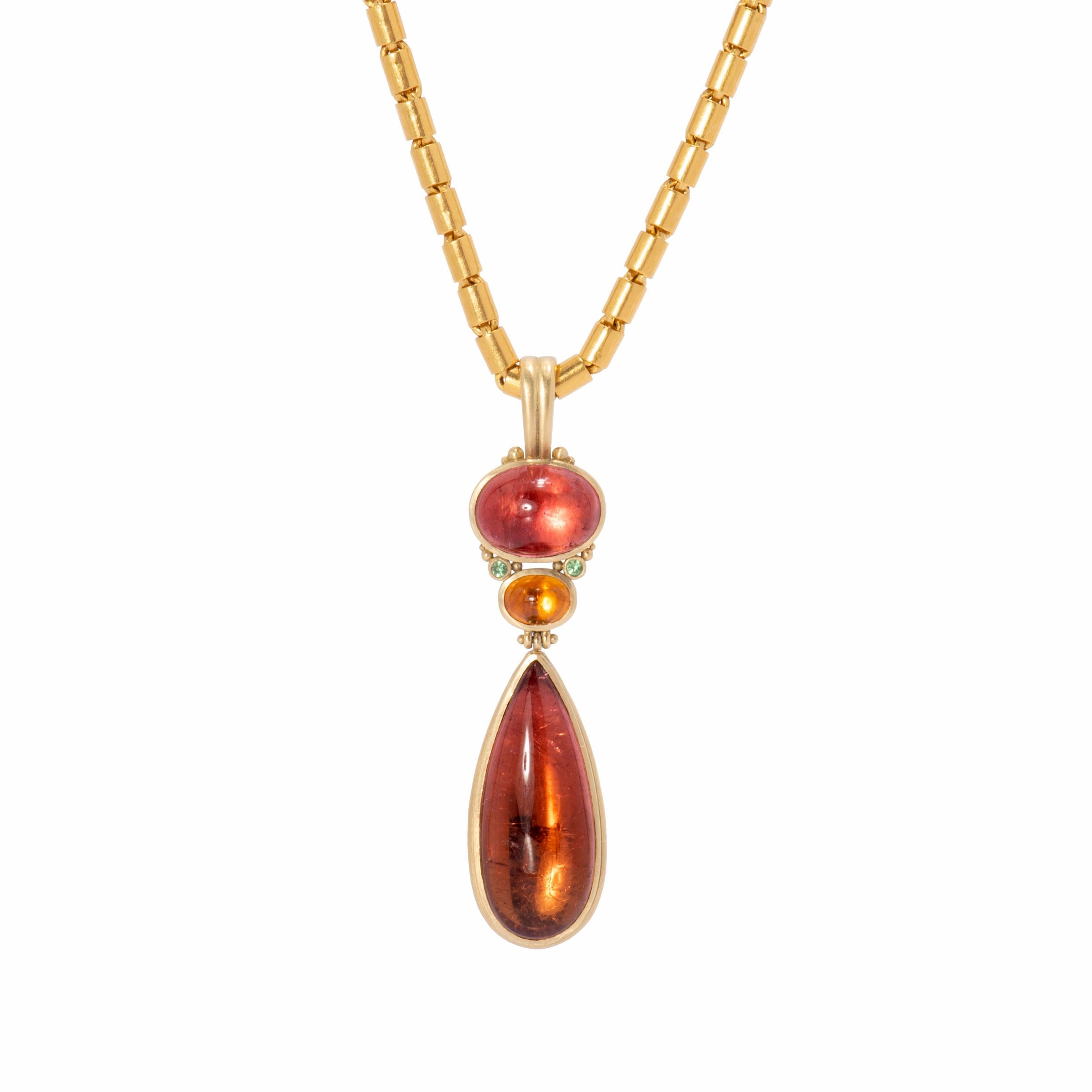 A spectacular Bi-Color Tourmaline teardrop 23.9cts dangles from the Tassel Pendant in rose colored honey tones. Mounted with an oval Pink Tourmaline 8.59cts and centered with a fiery Orange Spessartine Garnet 2.18cts, the Tassel Pendant is hand