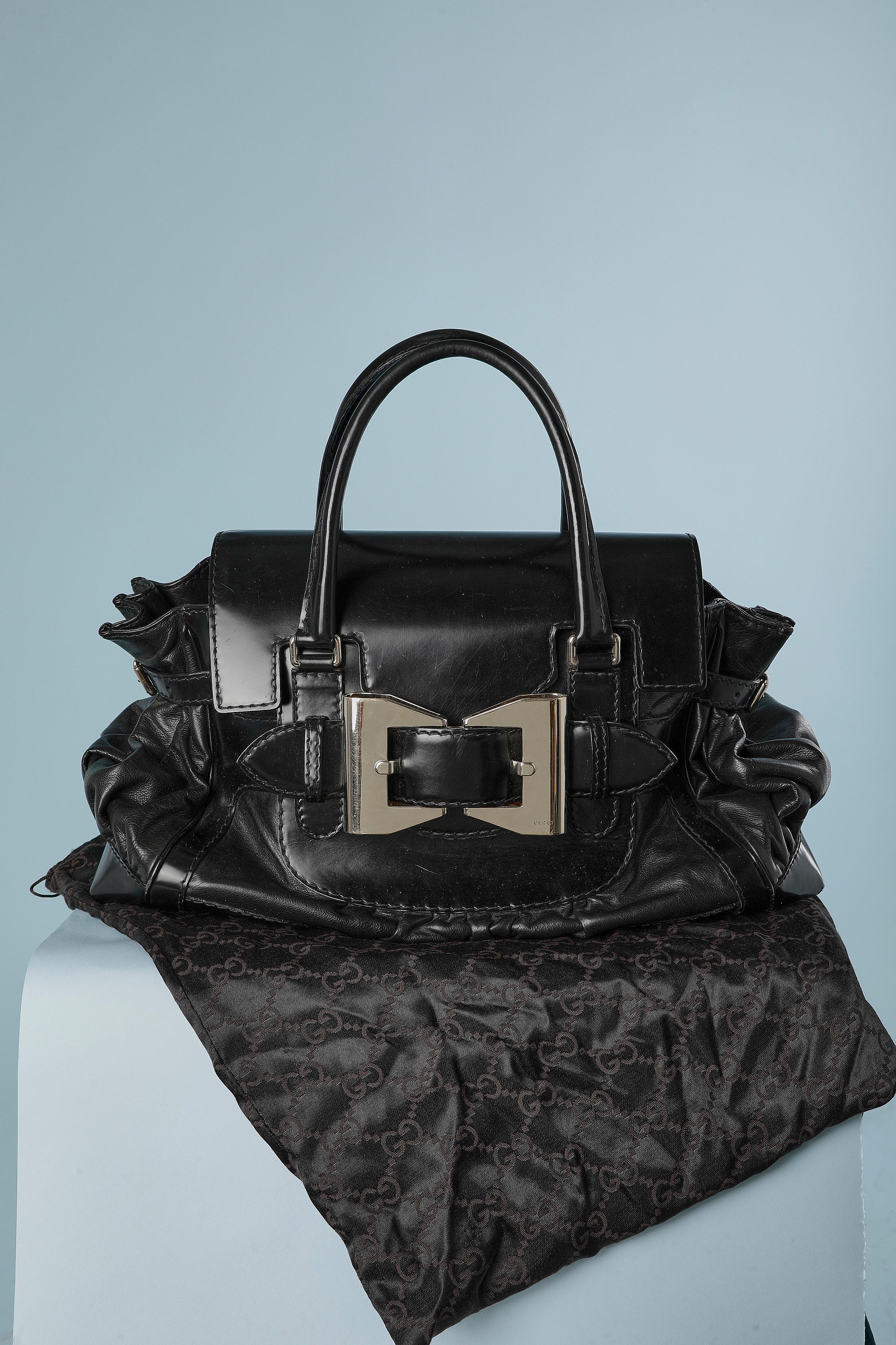 Bi-leather top handle bag with decorative silver metal buckle on the front. The top flap slips under the buckle. 
Dust-bag provided. One inside pocket with zip closure and 2 flat inside pocket. Branded nylon lining.
SIZE : 45cm X 30cm X 8cm