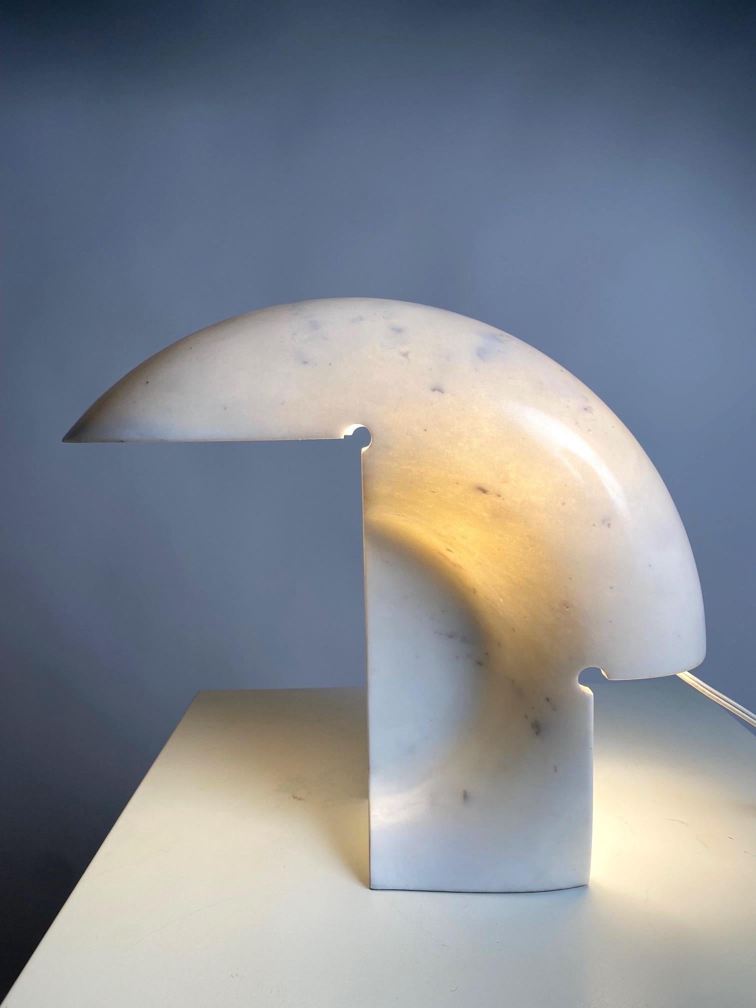 One of the most iconic and elegant lamps of Italian design, designed by the great architect and designer Tobia Scarpa and made entirely by carving out a single block of marble.

It gives off a warm and enveloping light, which filters through the