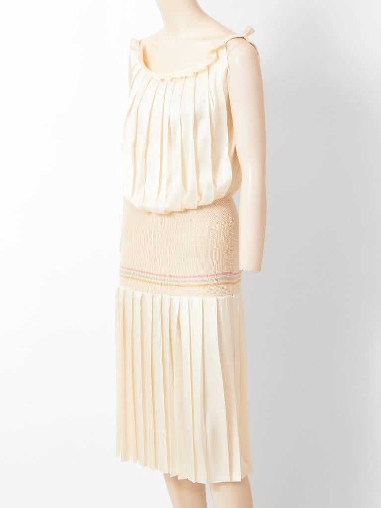 Laura Biagiotti, ivory silk, sleeveless, pleated dress, having a scoop neckline, and a blouson bodice. There is a knit fabric that starts at the waist and extends to the hip, creating a drop waistline.