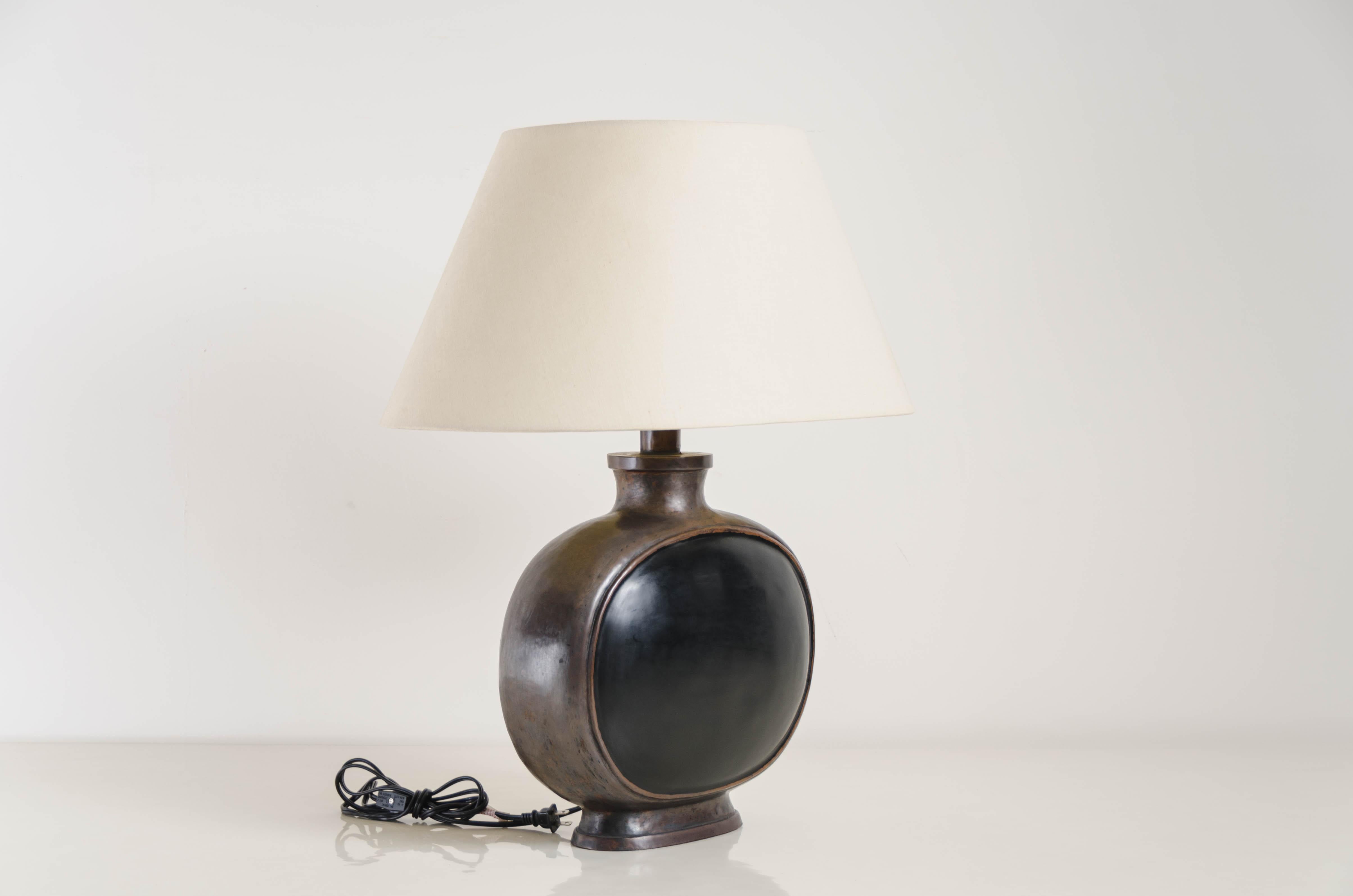 Bian Hu table lamp
Black lacquer
Antique copper
Hand respoussé
Silk shade
Handmade

Respoussé is the traditional art of hand-hammering decorative relief onto sheet metal. The technique originated circa 800 BC between Asia and Europe and in Chinese