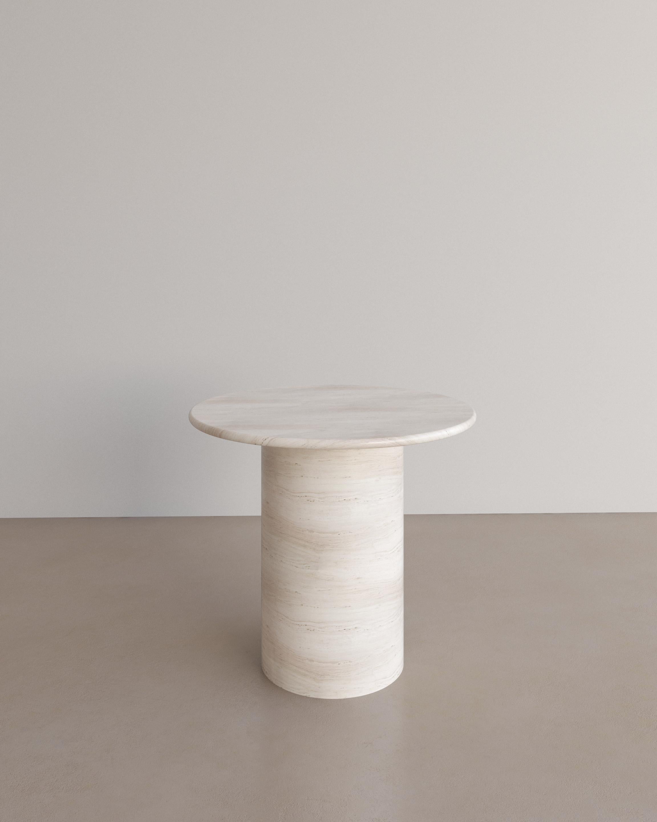 The Essentialist presents the Voyage Occasional Table I in Bianco Travertine. 
The Voyage Occasional Table I celebrates the simple pleasures that define life and replenish the soul through harnessing essential form. Envisioned as an ode to