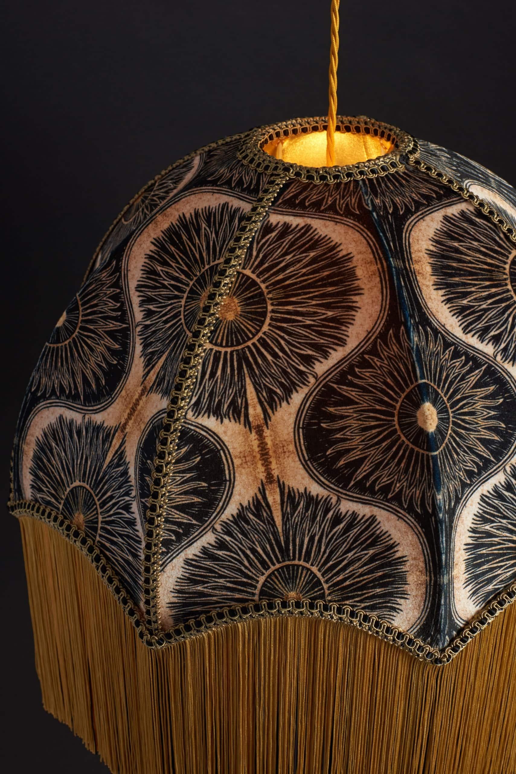 Bibana is our signature design, beautifully displayed on a timeless fringed lampshade. Created by Anna from a linoprint, this decadent black and gold floral print lends itself to many different eras creating a vintage bohemian vibe.

Anna Hayman
