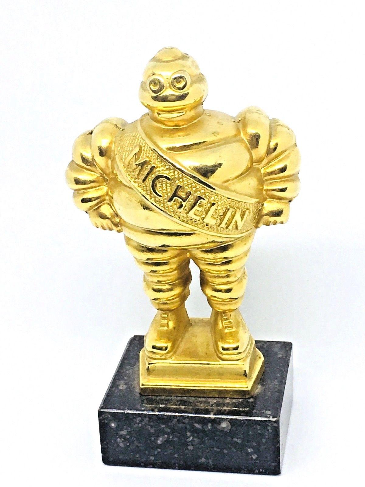 Gorgeous vintage Bibendum Michelin Man Trophy statue. A beautiful decorative item in brass or gold-plated metal on a marble bass. Made in Europe circa 1980s. Probably a give away, award or Trophy from the Manufactory of Tires. Nice addition to any