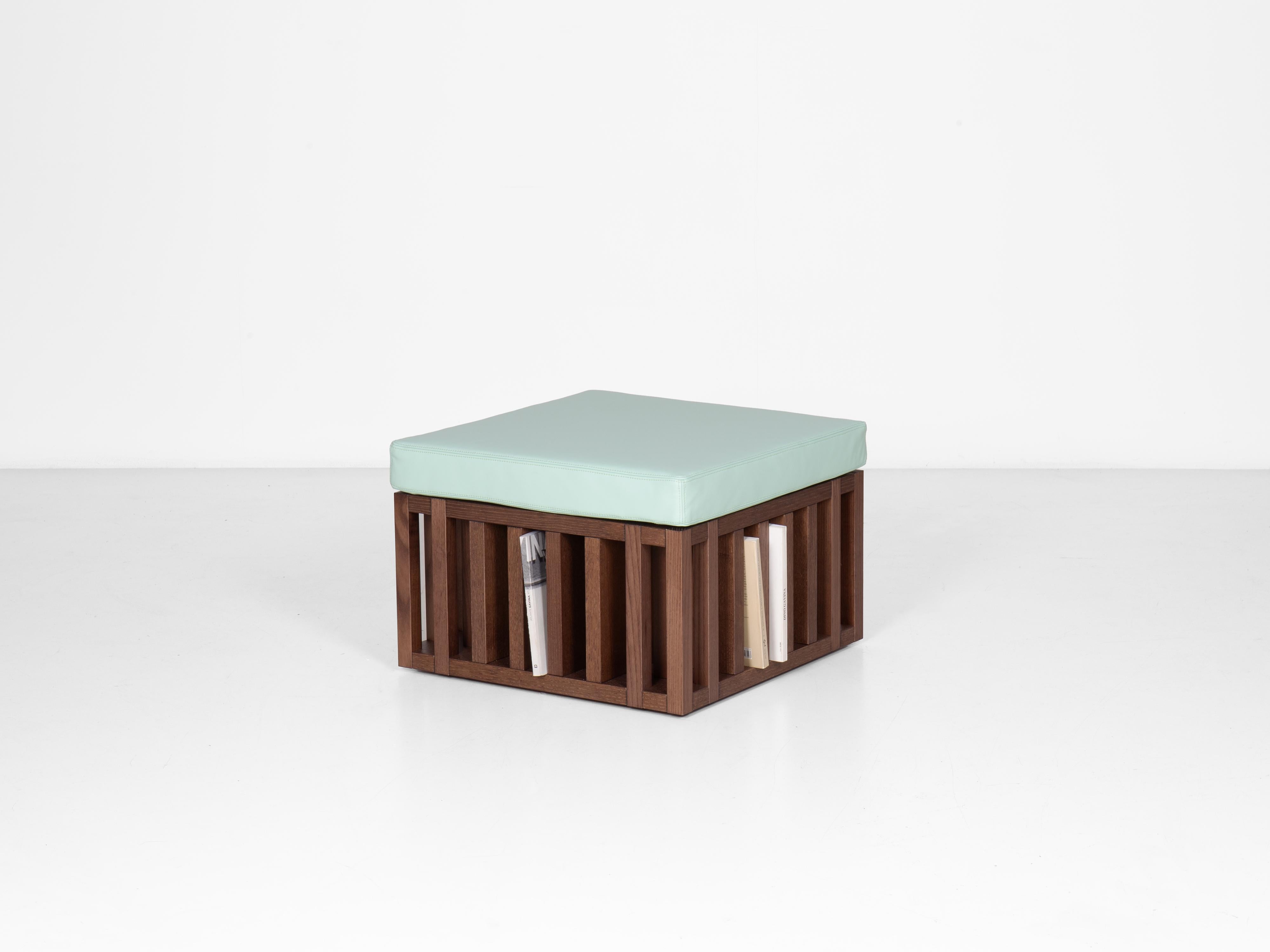 Bibliopouf, a footstool-bookcase by designer Giovanni Gennari.

Materials: composite veneered oak wood (natural or dyed) or matte lacquered wood, polyurethane foam padding, upholstery in leather available in different colors.

Originally produced by