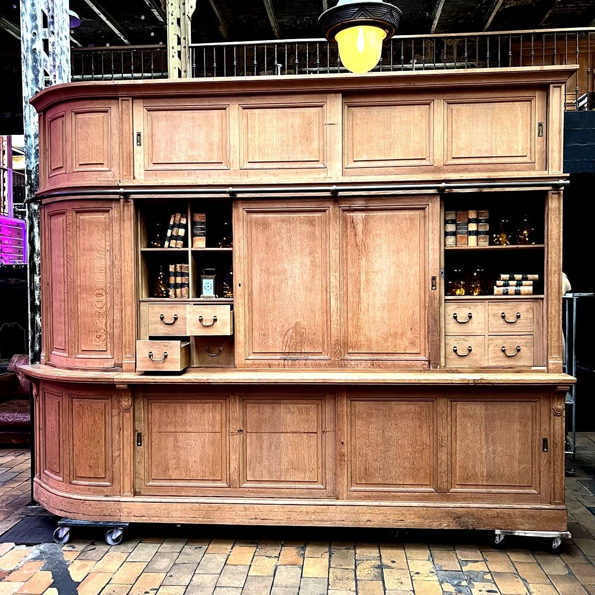 Elegant period bookcase from the Banque de France, carefully stripped to reveal the natural beauty of the wood. Featuring numerous storage spaces, drawers, and shelves, this exceptional piece combines historical charm and functionality. Its classic